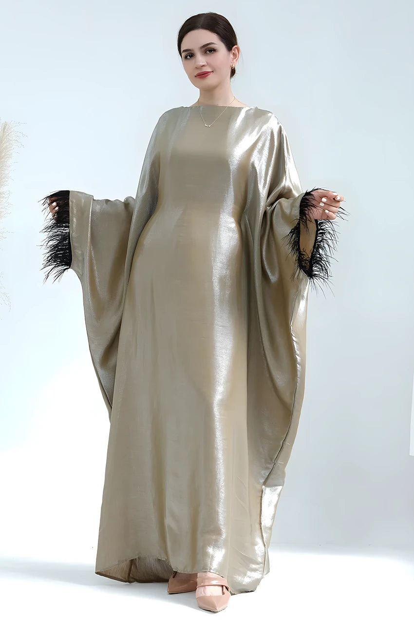 Close-up of black feather cuffs on green Alara satin kaftan gown