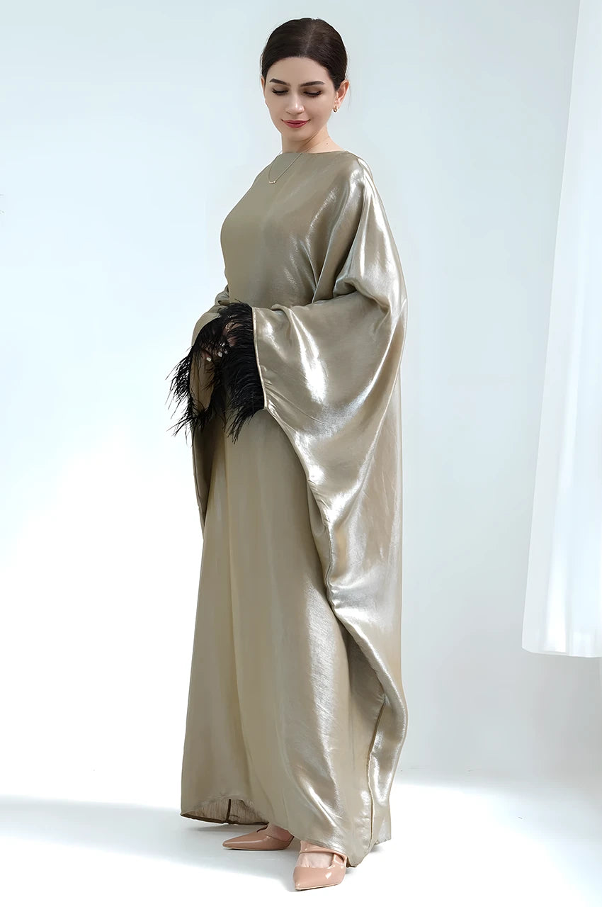 Side profile of Alara green satin kaftan gown with black feather sleeve detail