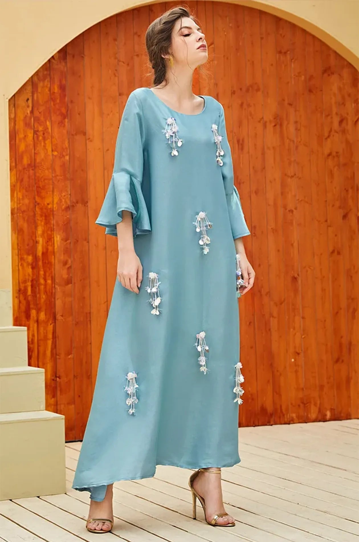 Elegant posture showing the drape of the Alima aqua blue kaftan.