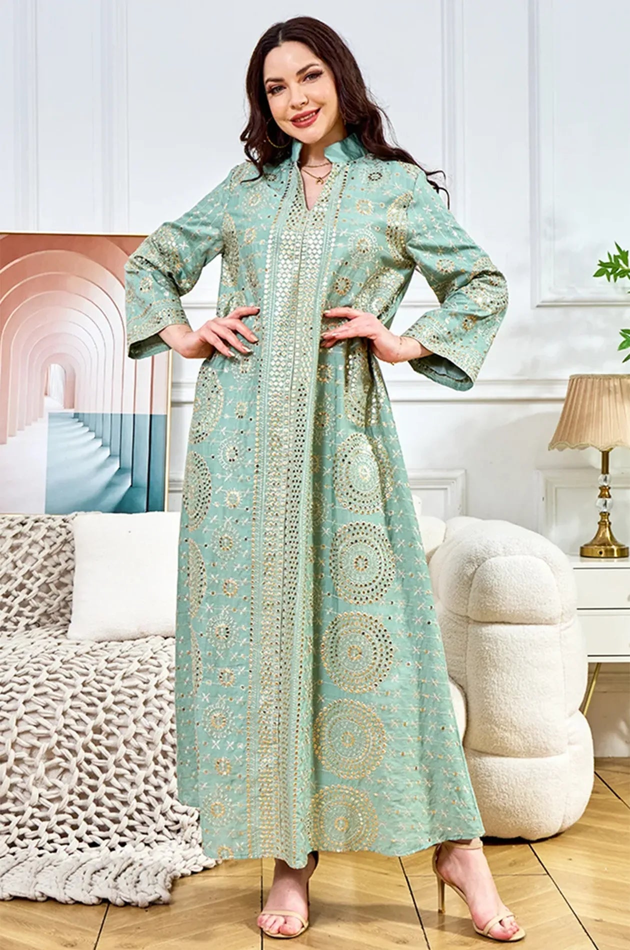 Model posing in the Aluna light green mirror kaftan in a modern lifestyle setting, showing the full front design.