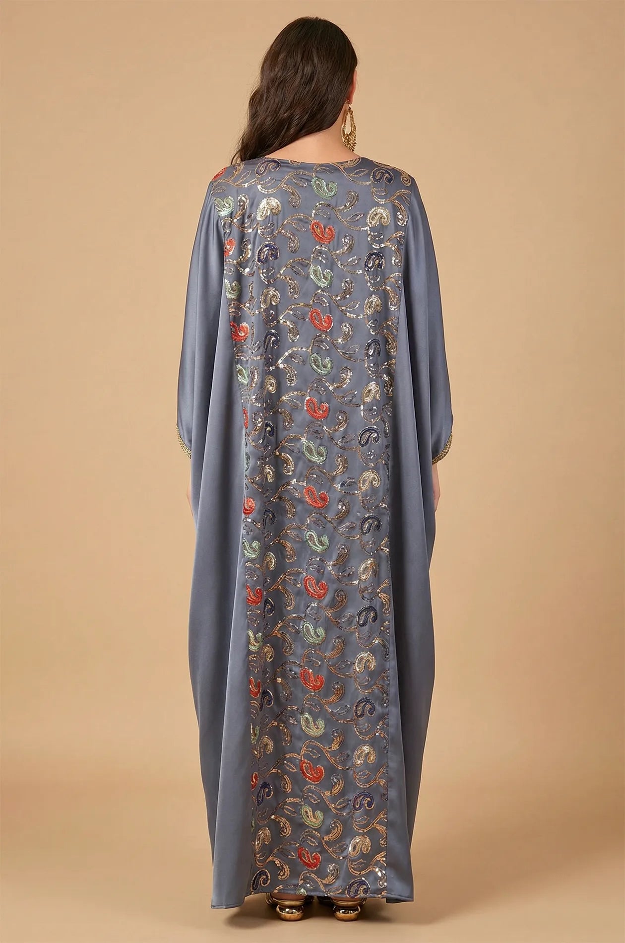 Rear perspective of the gray Amiri farasha kaftan showcasing the continuous sequin panel design down the back.