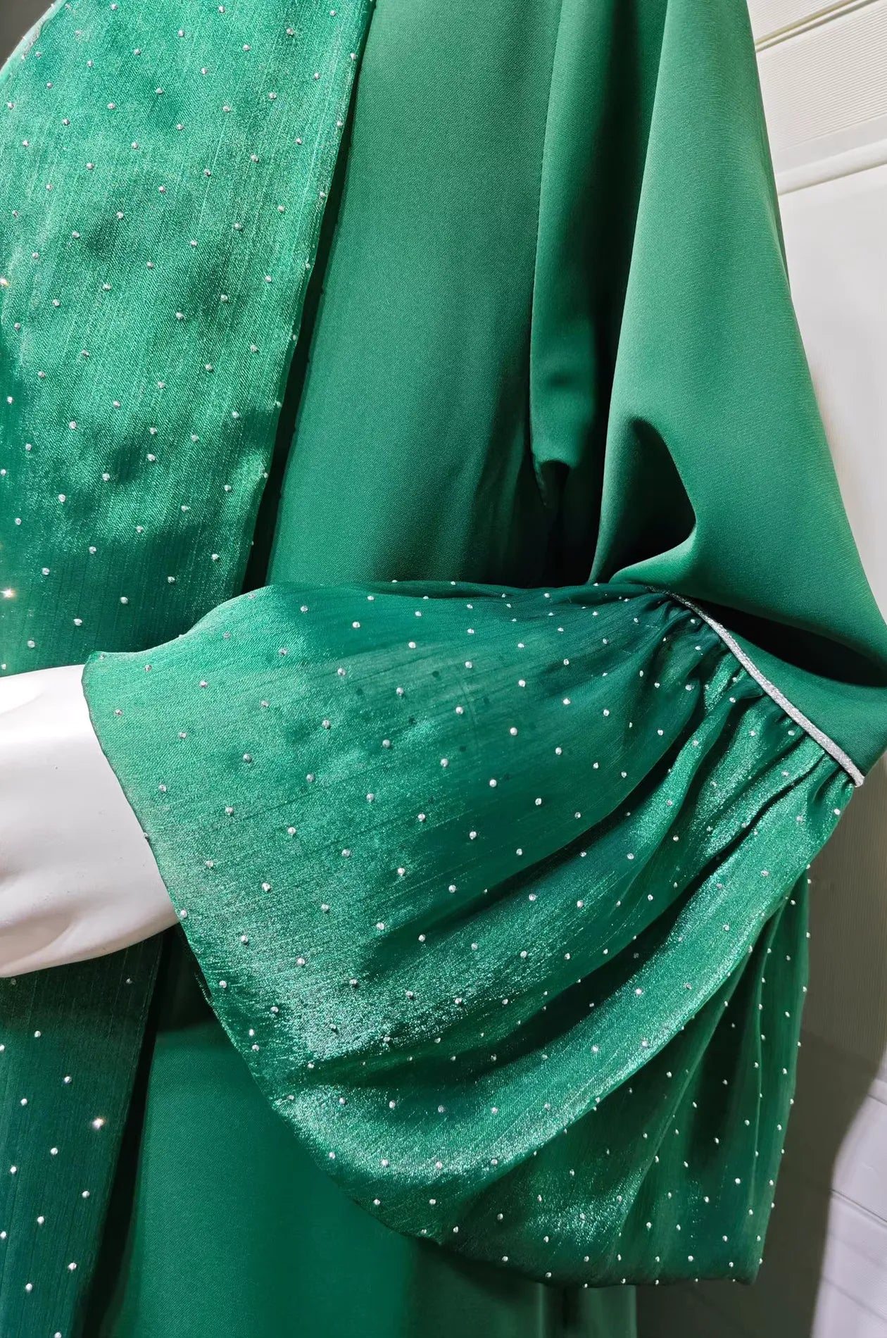 Close-up detail of the Auris Green Kaftan sleeve, showcasing the premium lightweight crepe fabric and hand-applied rhinestone dots.