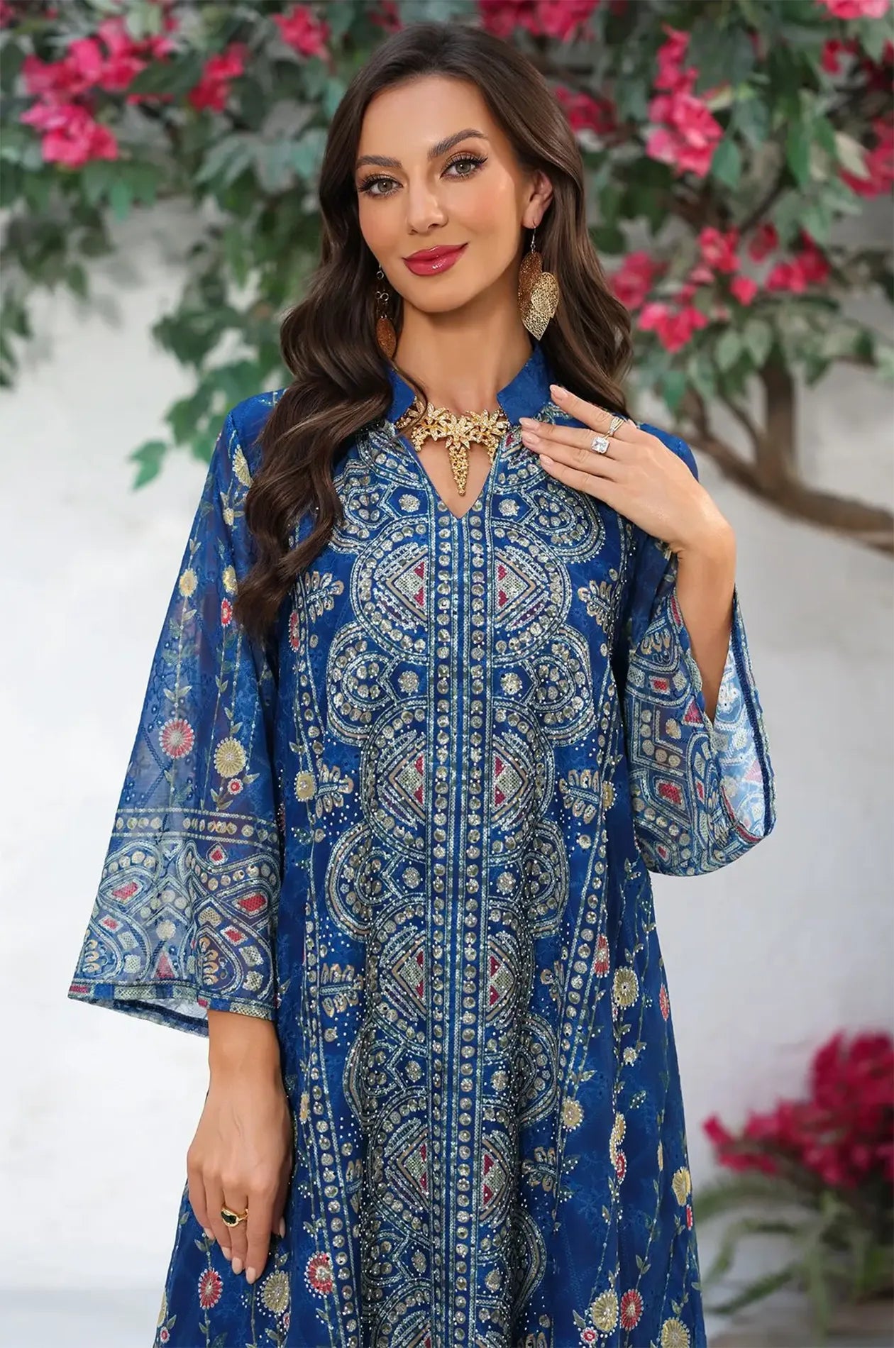 Close-up of the Azari navy kaftan's ornate V-neckline and intricate gold-toned geometric bodice print.