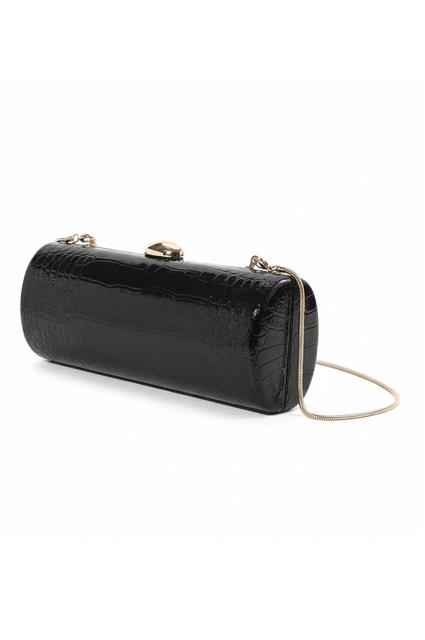 Angled view of the black hard shell cylinder clutch showing the rounded profile and gold chain attachment.