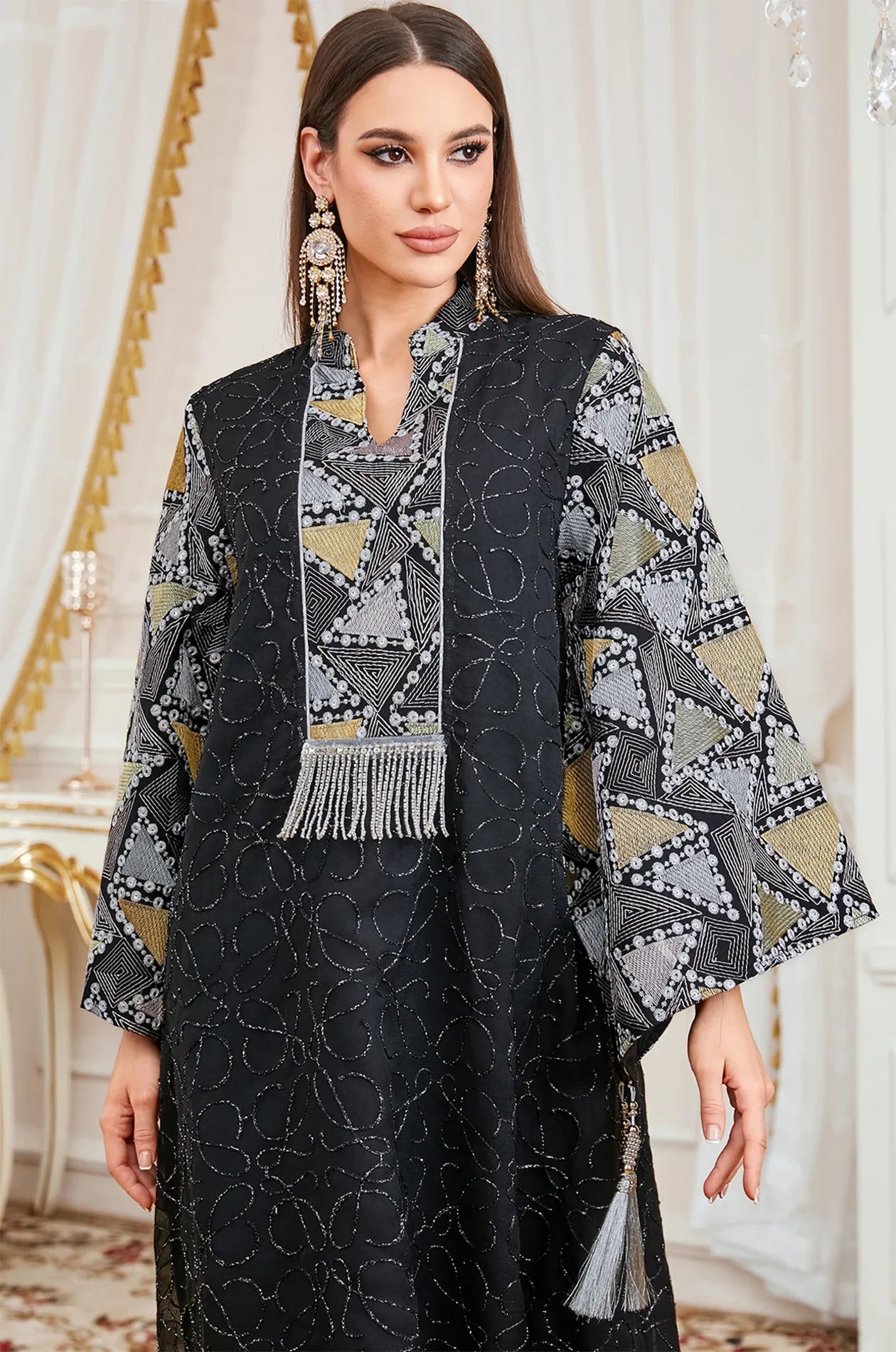 Close-up detail of the Black Kaliera kaftan’s V-split neckline, silver fringe tassel, and hand-finished embroidery.