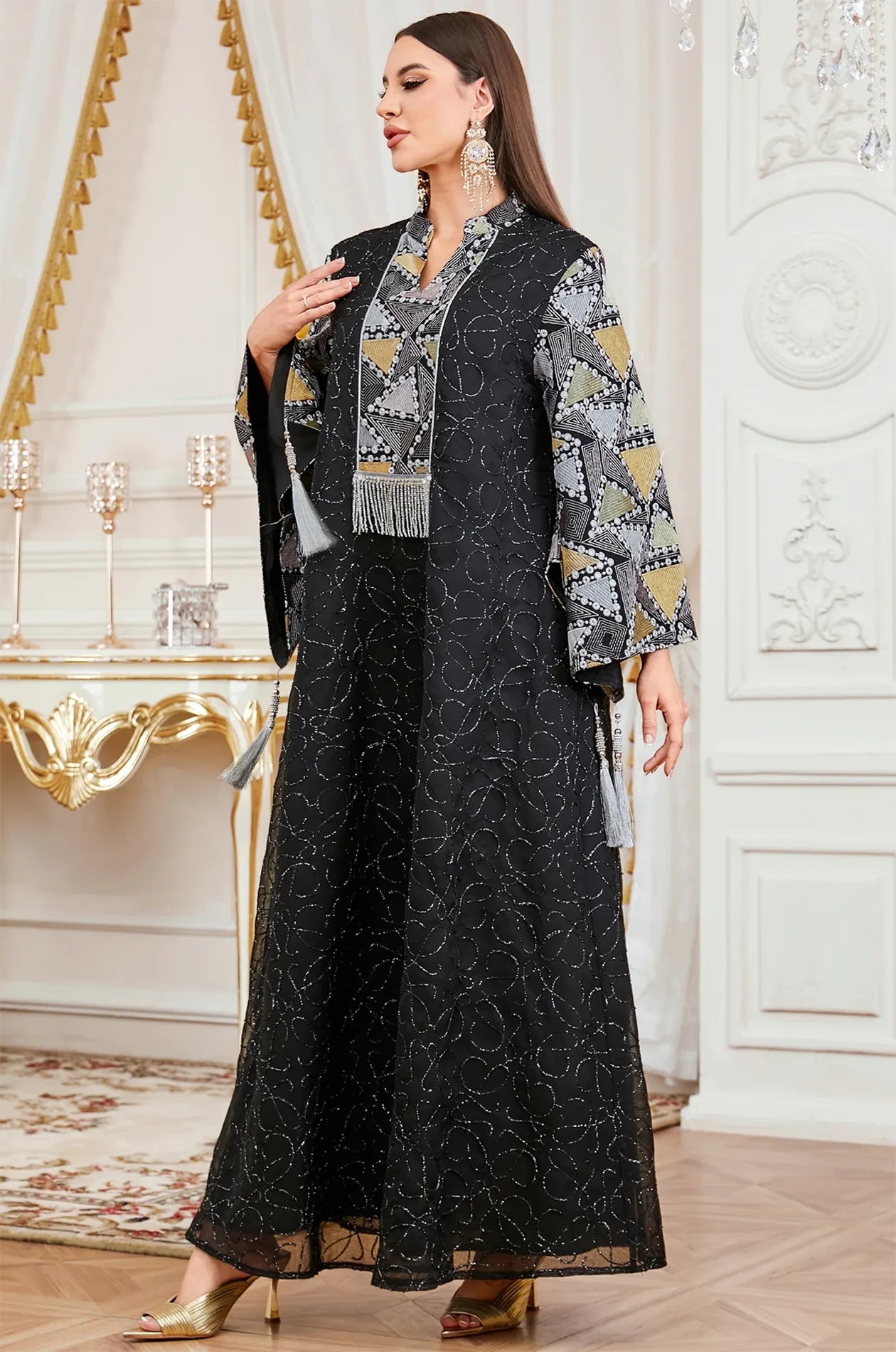 A luxury interior shot of the Black Kaliera geometric kaftan, highlighting the shimmering threadwork and ornate formal design.