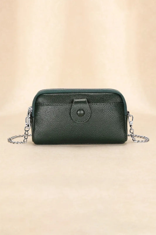 Front view of black pebbled leather crossbody phone bag with snap pocket and silver chain strap.