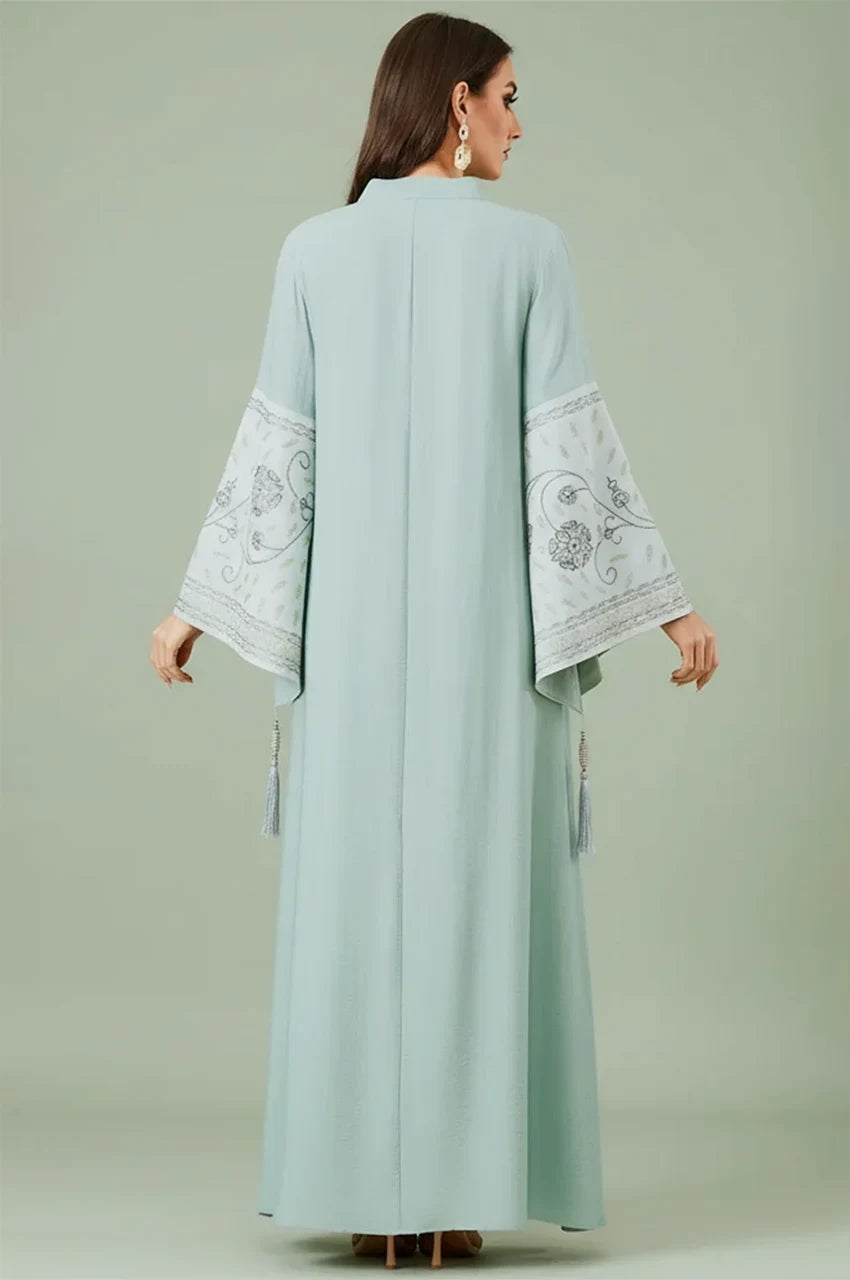 Back profile of the Cyan Nairi cotton kaftan maxi by Naylara, highlighting the embroidered patterns on flared sleeve.