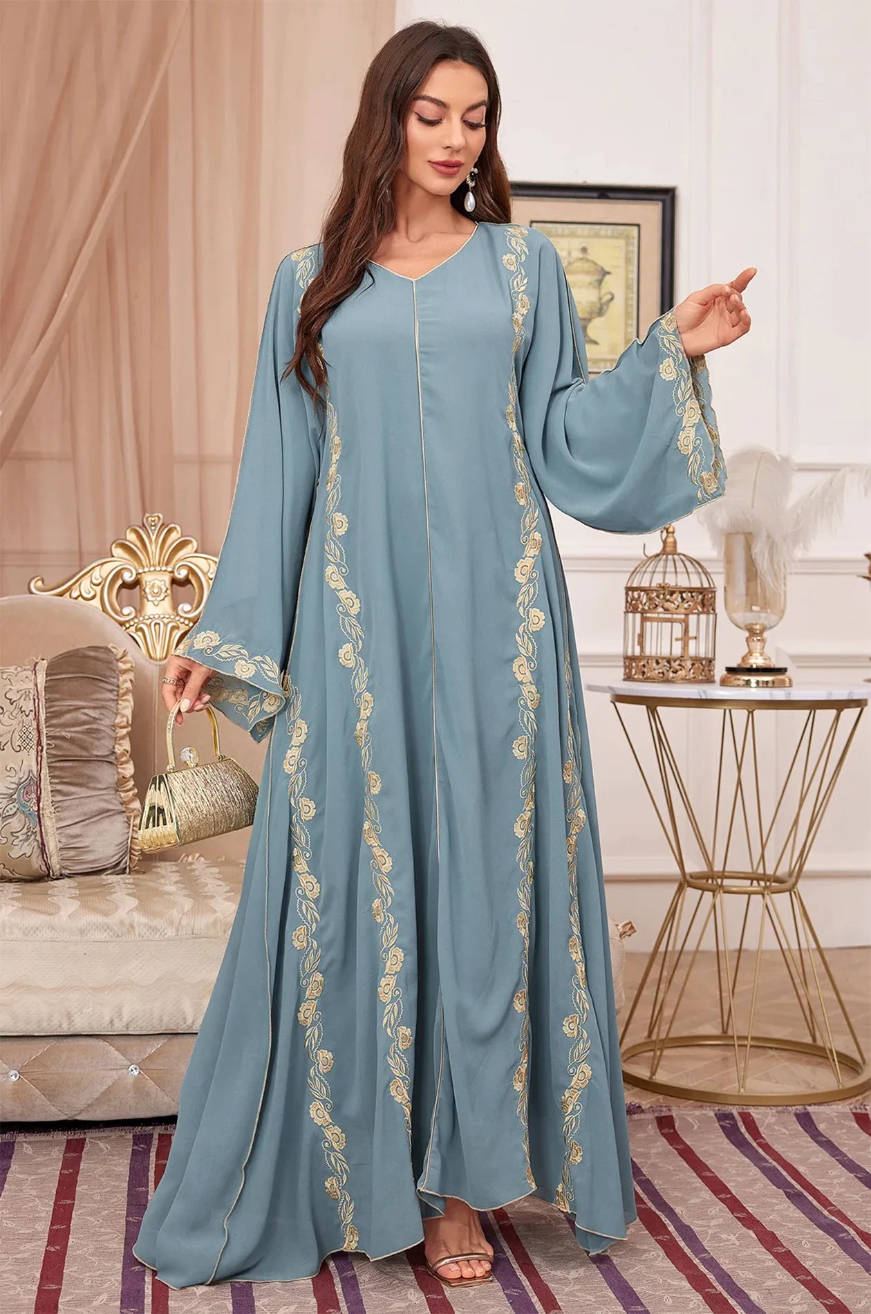 Tahra kaftan styled with a gold clutch for a formal evening look.