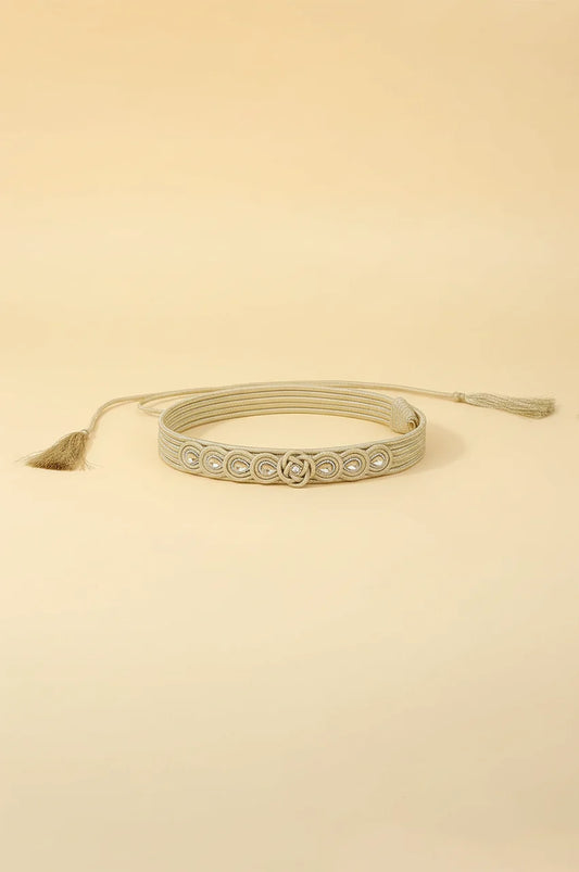 Coiled champagne gold braided waist belt showing flexibility and adjustable rope closure.