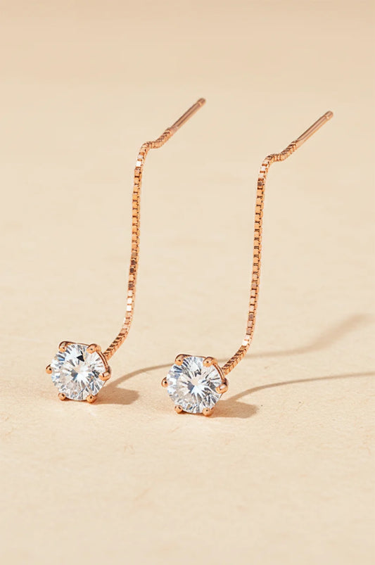 Minimalist gold chain pull-through earrings displayed on a beige background.