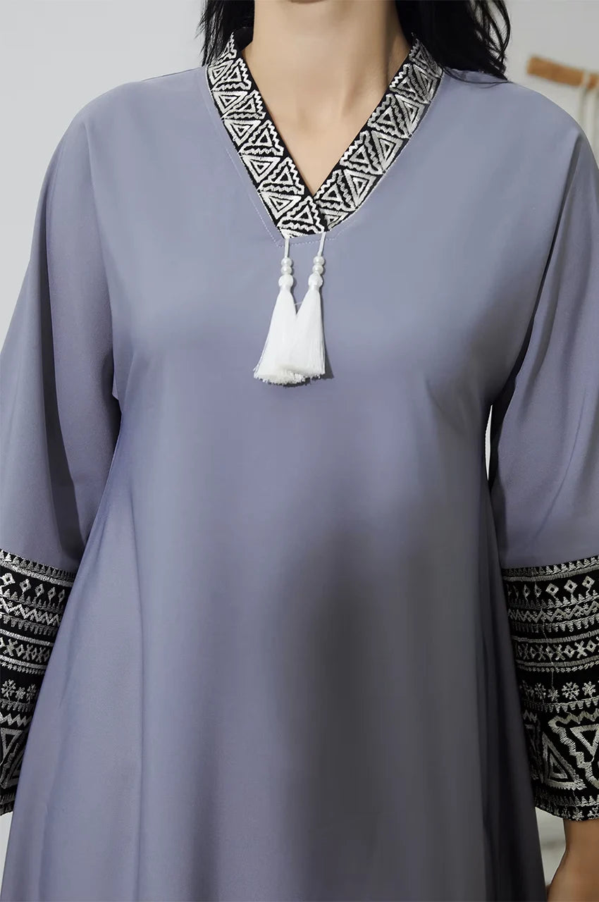 Close up of V-neck embroidery and tassels on Keyla gray kaftan.