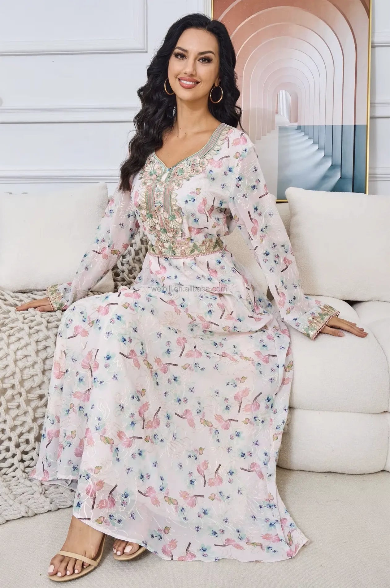 Detailed view of the Ilani kaftan while seated, showcasing fabric texture and drape.