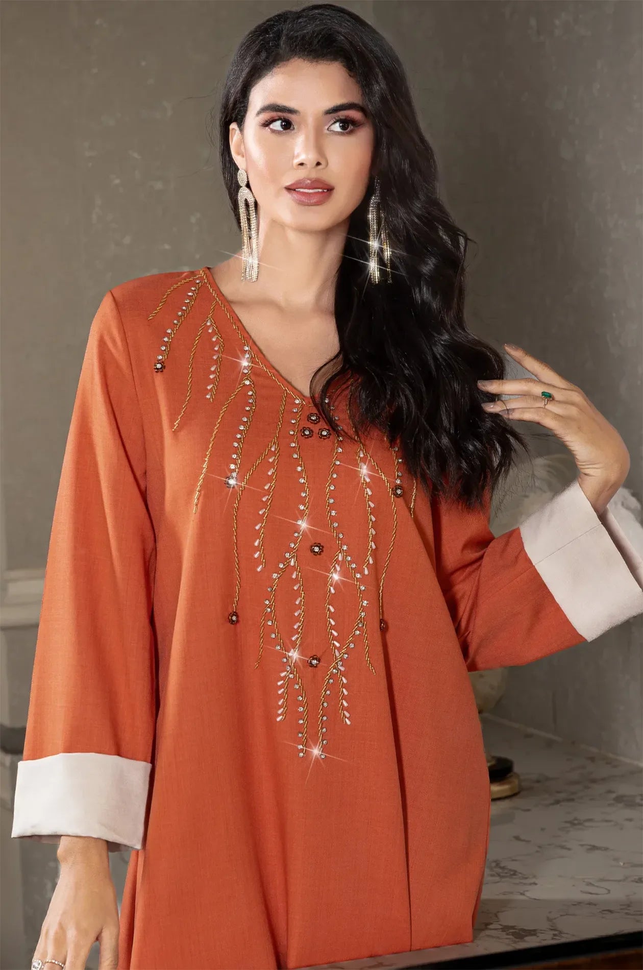 Close-up of the gold rhinestone and bead embellishments on the orange kaftan.