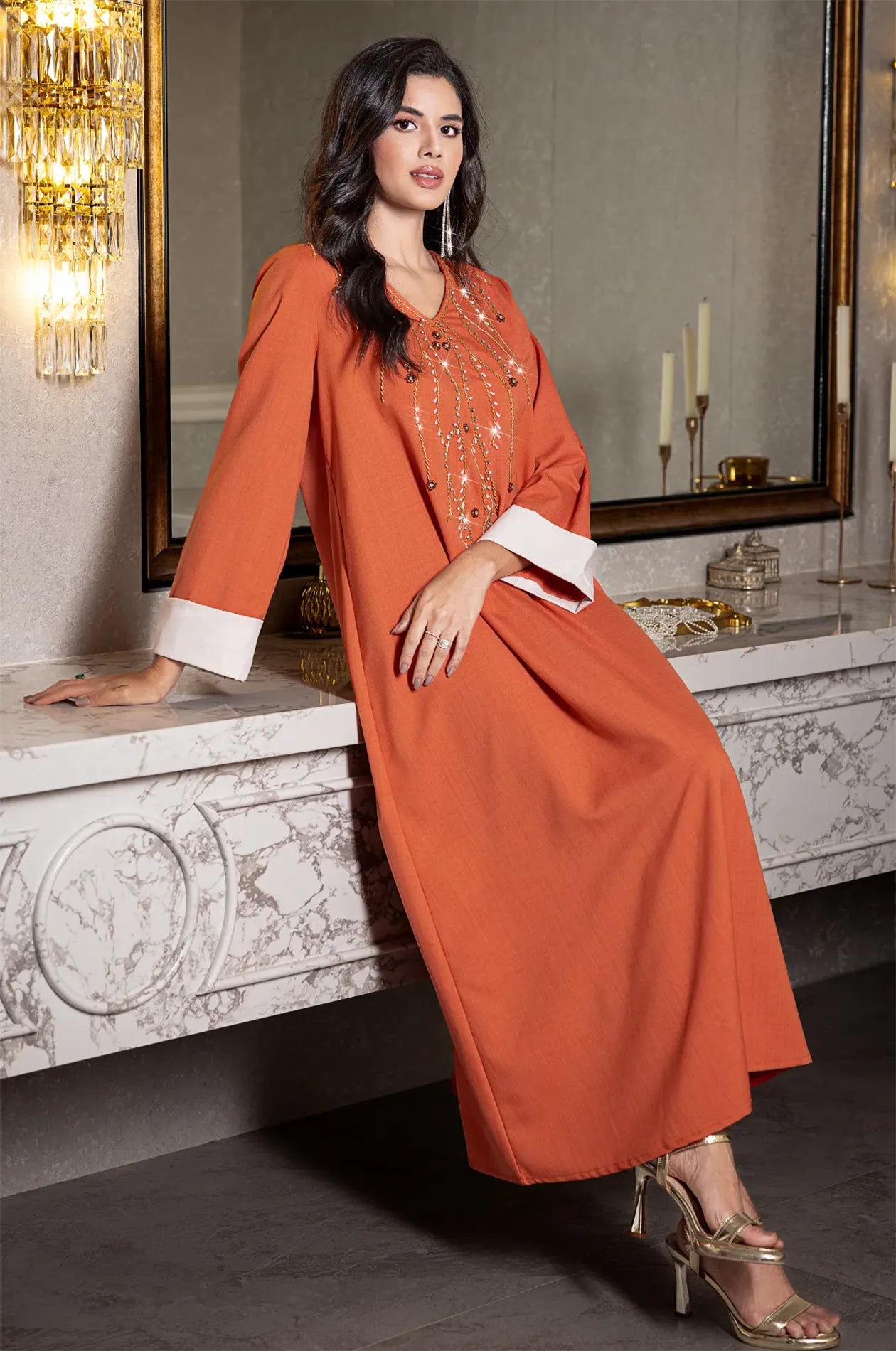 Lifestyle view of the orange Ilena kaftan showing the fabric's movement and drape.