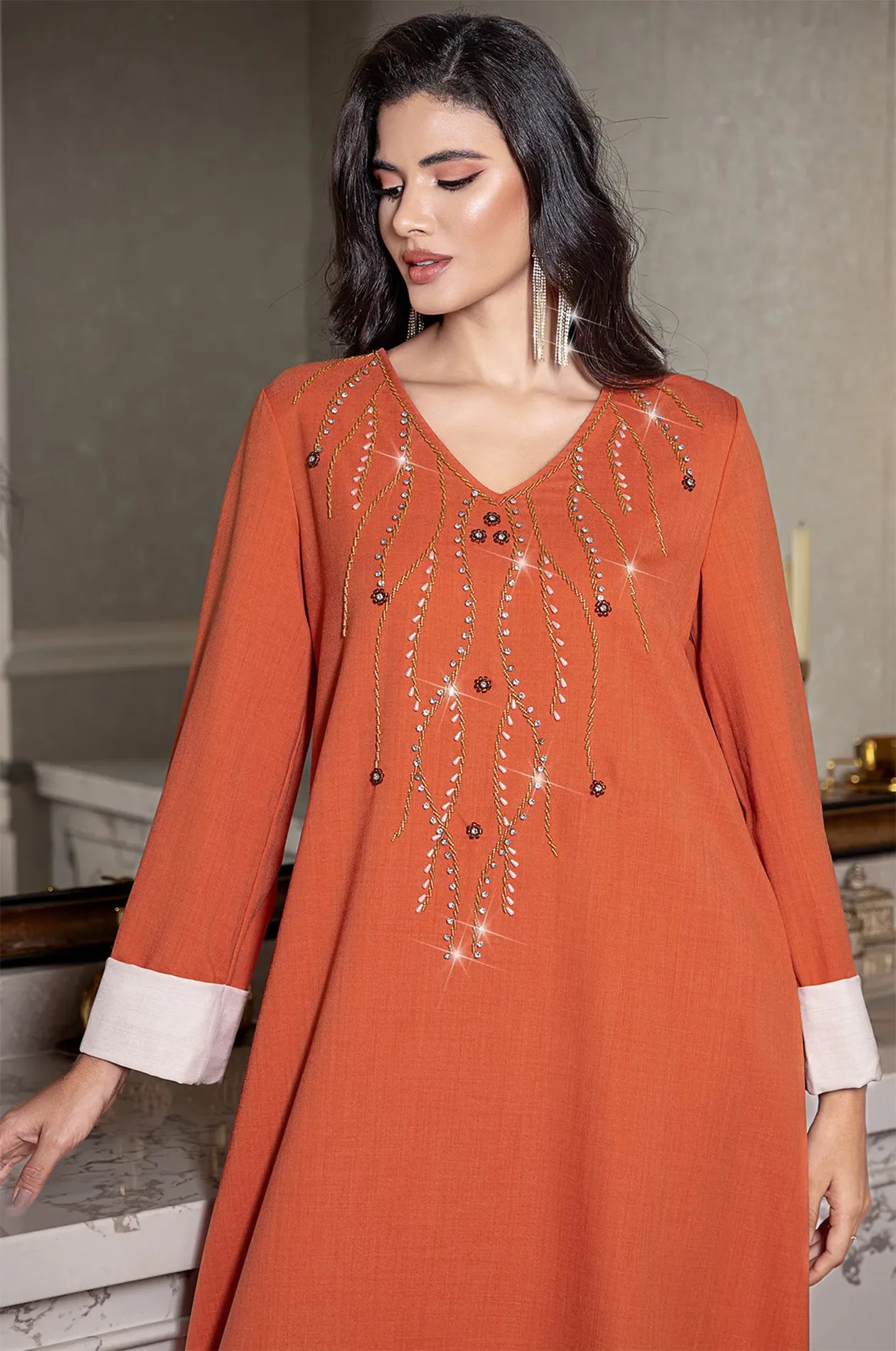 Detailed view of the V-neckline embroidery on the Ilena orange kaftan.