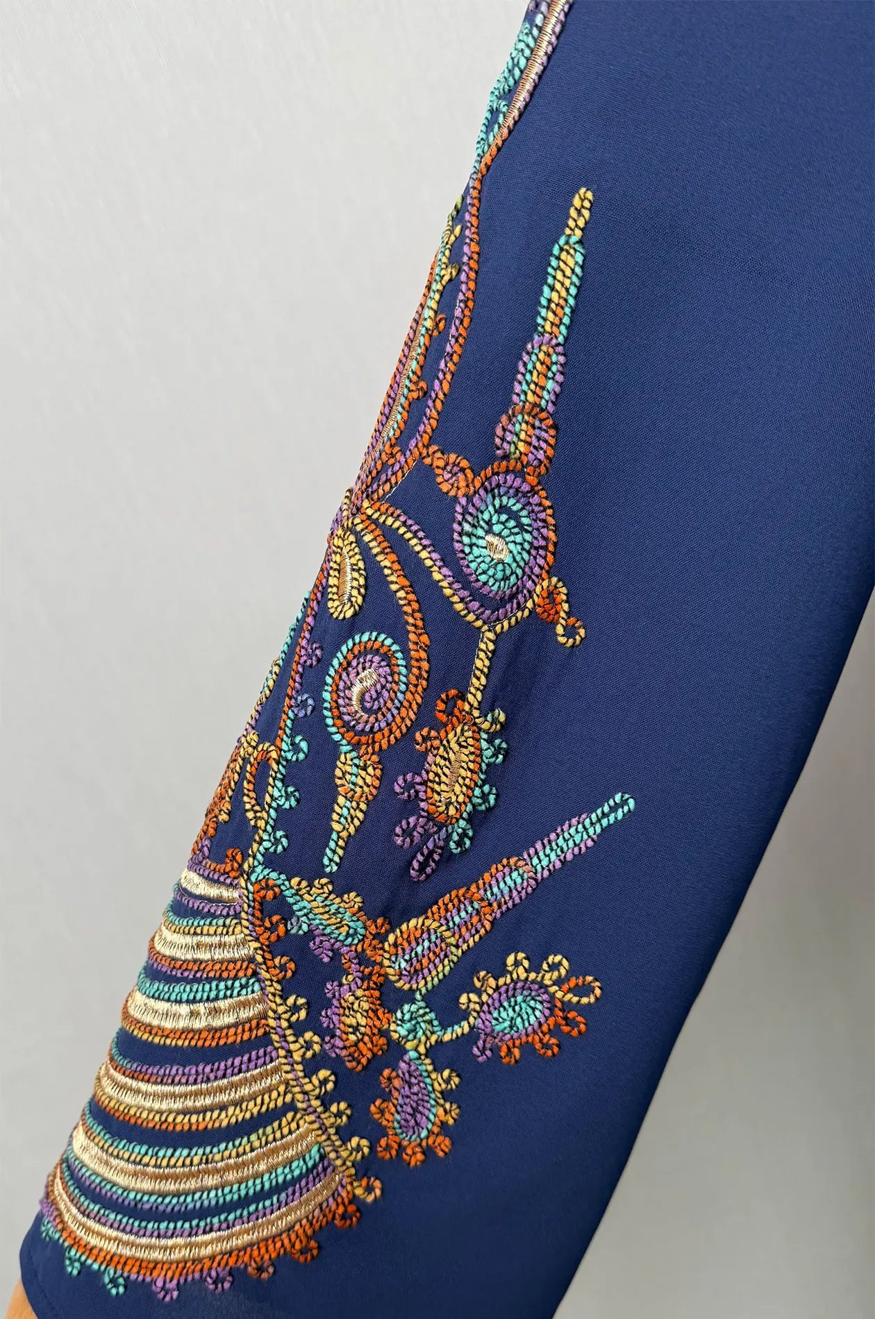 Detailed close-up zoom of the traditional embroidery patterns on the bell sleeve of the Inez Blue Jalabiya Kaftan.