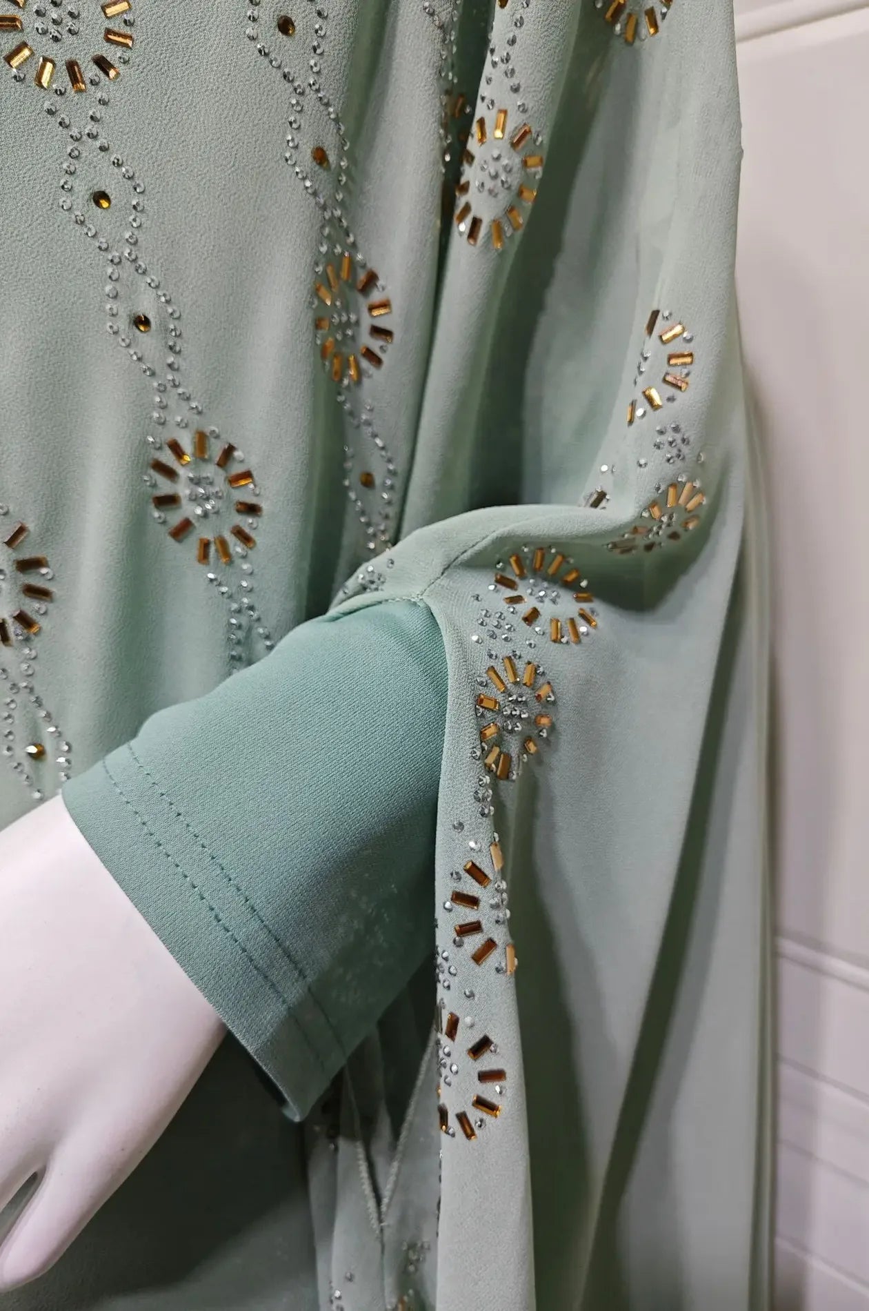 Macro shot of the high-quality rhinestone embroidery on the sleeve of the Light Green Cassia Kaftan.