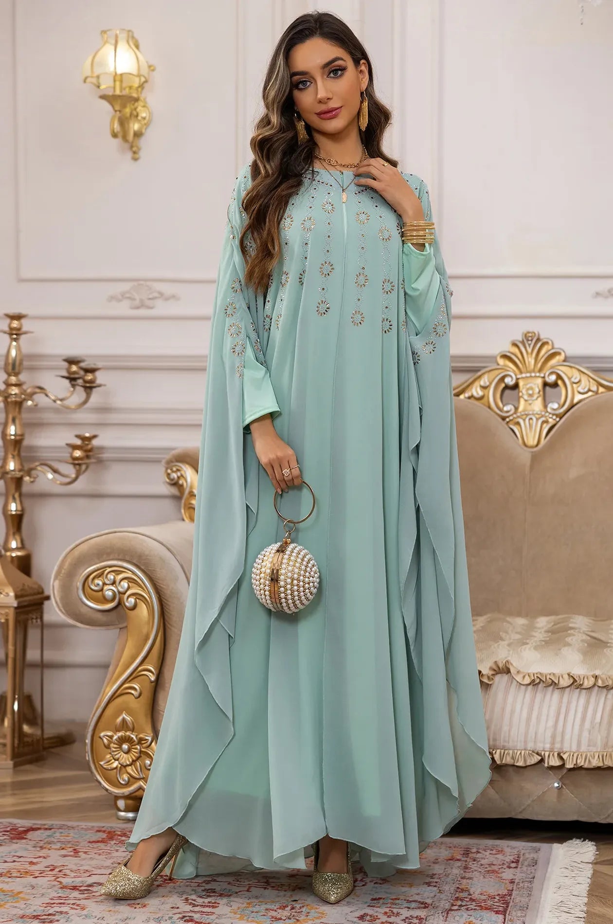 Front view of the Light Green Cassia Rhinestone Kaftan styled with a pearl evening bag for a party look.