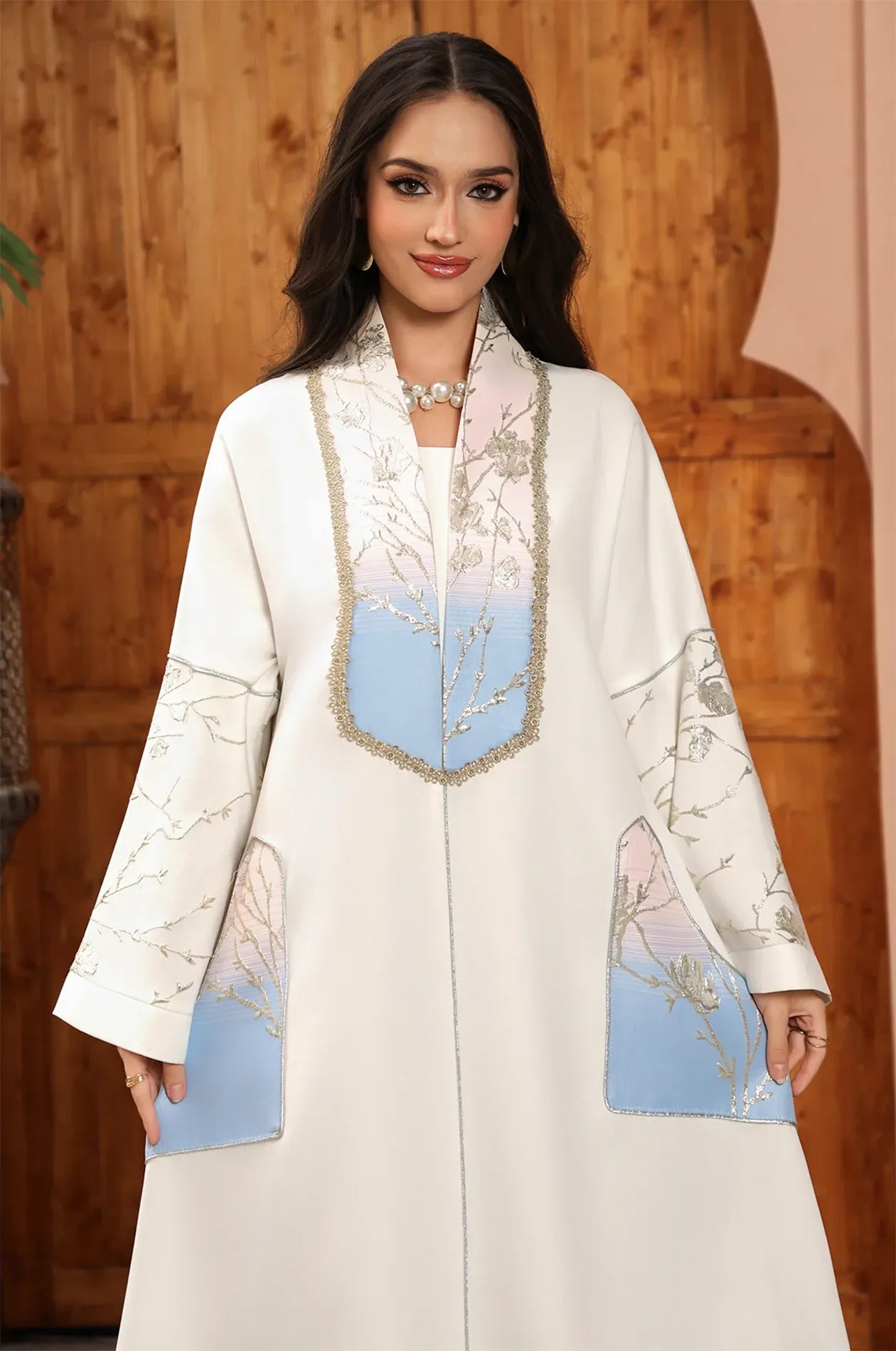 Detailed view of the Liorra Light Blue Kaftan Ombreβs embroidery and gold-braided trim, accessorized with a pearl necklace.