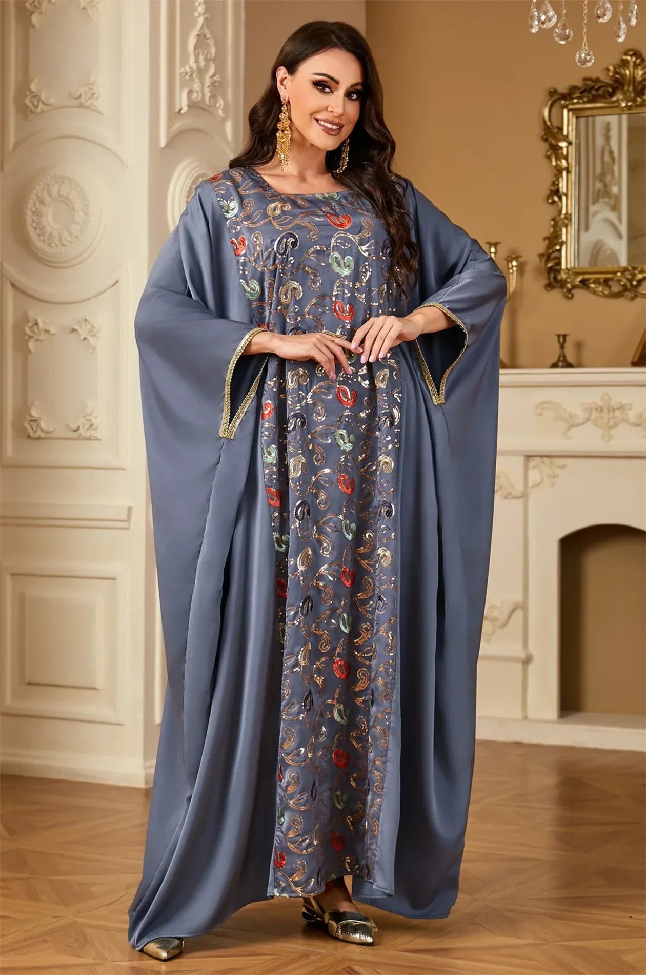 Model posing in the luxury gray Amiri farasha kaftan highlighting the intricate vertical embroidery and modest fit.