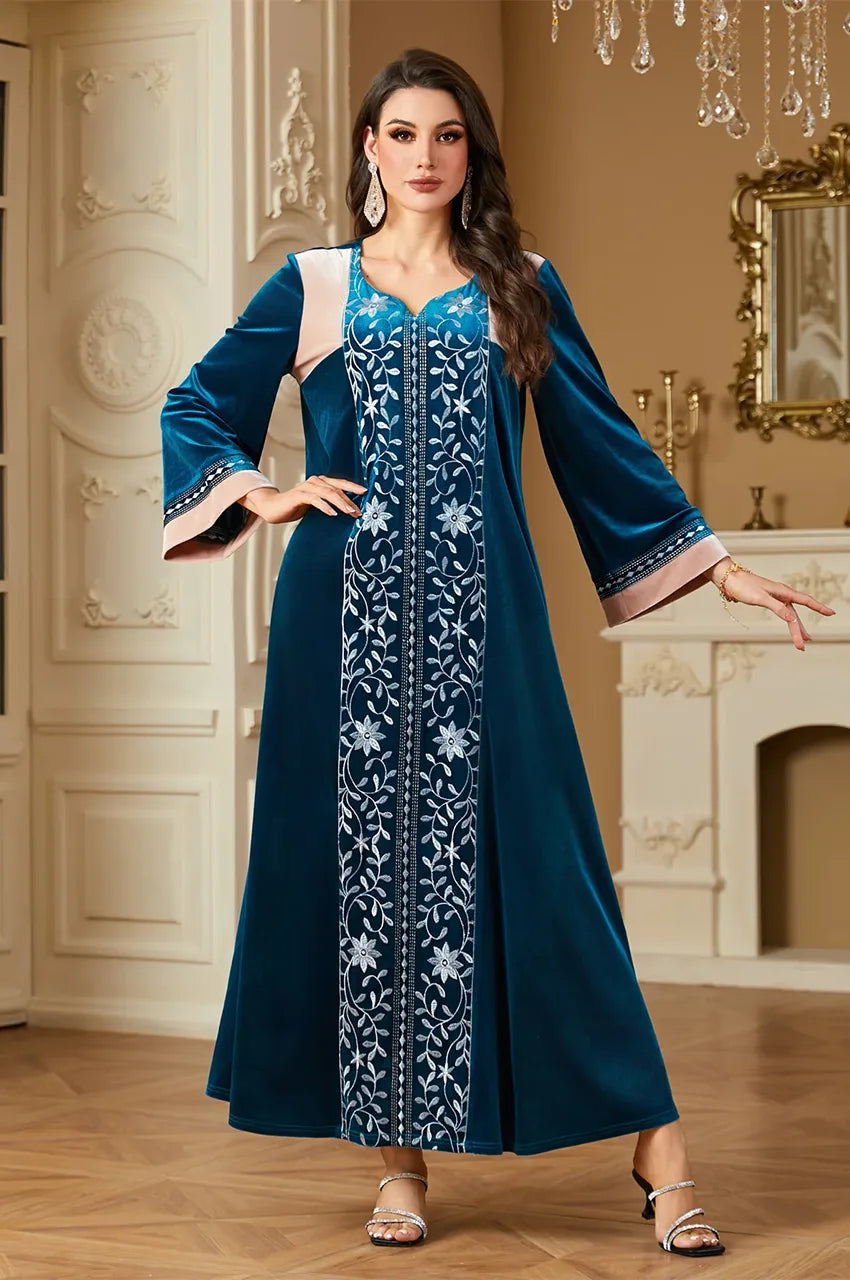 Close up of Lylah kaftan showing intricate silver floral embroidery on teal velvet.