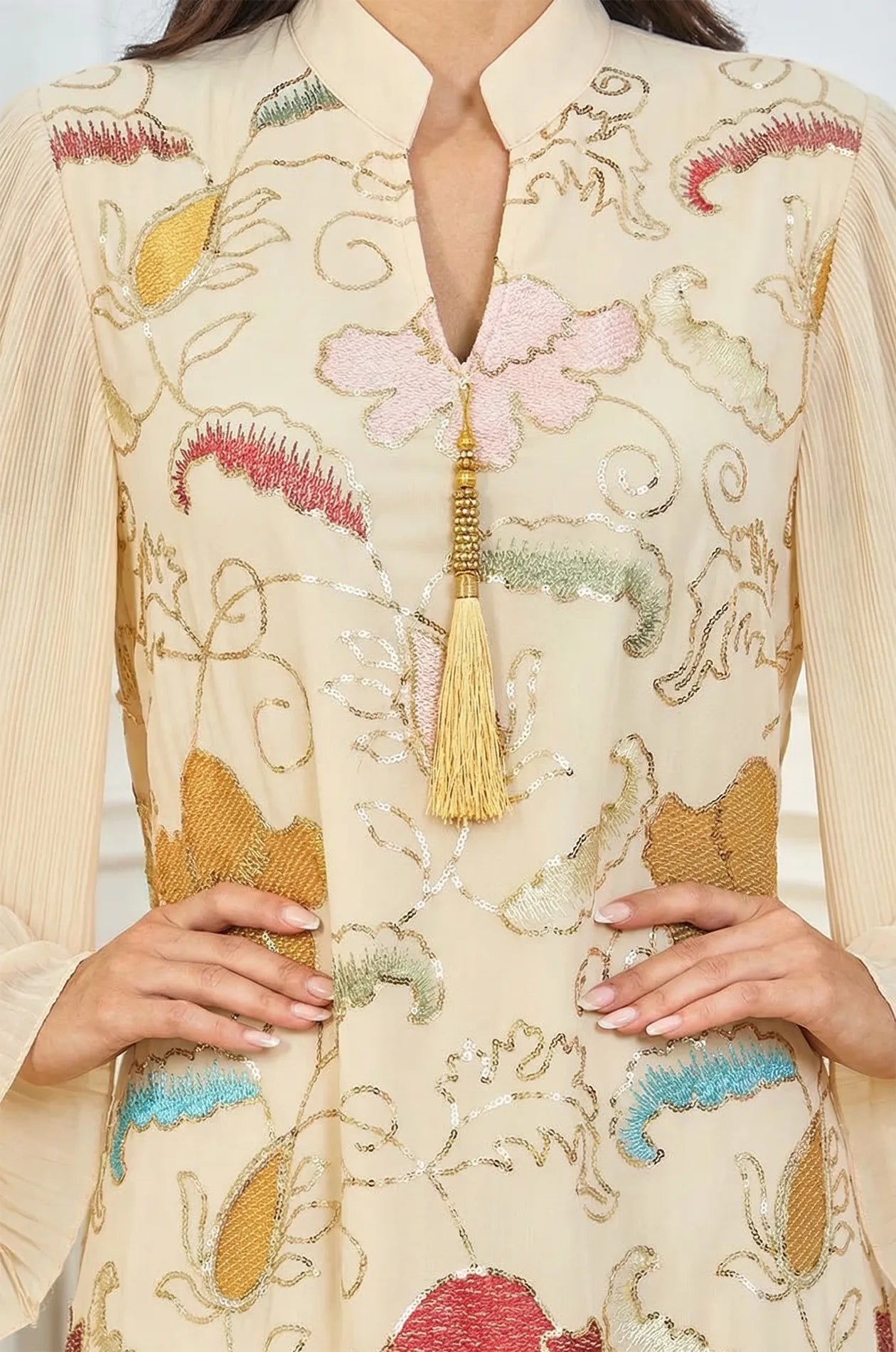 Close-up detail of the Marylin Beige Kaftan bodice, featuring the gold-toned tassel, V-neck collar, and hand-finished sequins.