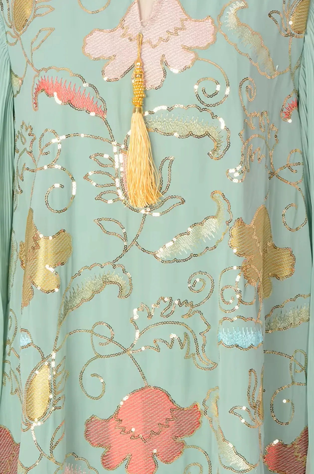 Macro view of the sage green chiffon fabric and shimmering hand-finished sequin embroidery on the Marylin Tassel Kaftan.