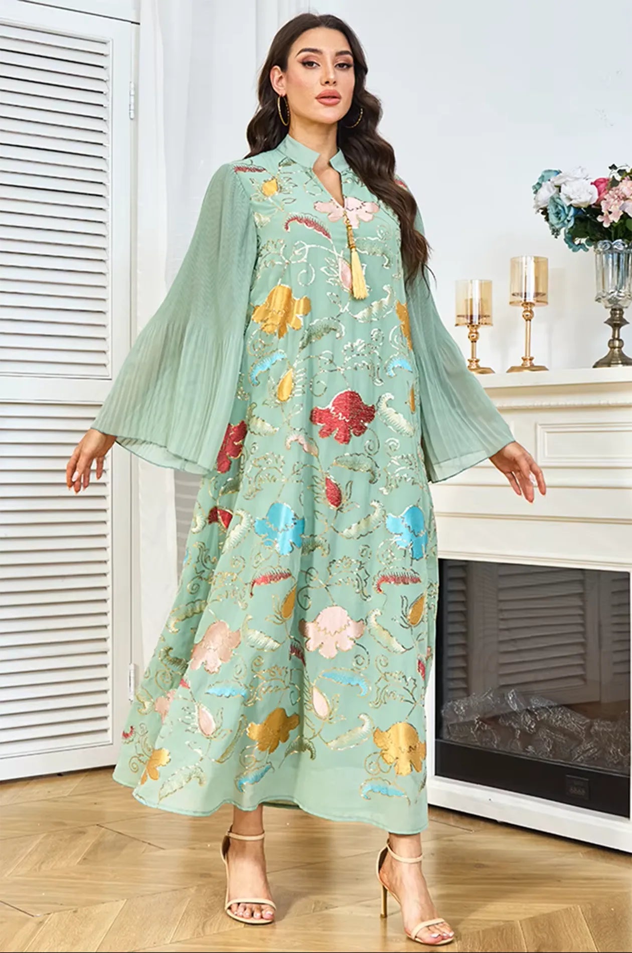 Model displaying the wide pleated bell sleeves of the Marylin Green Tassel Kaftan to show the fabric volume and texture.