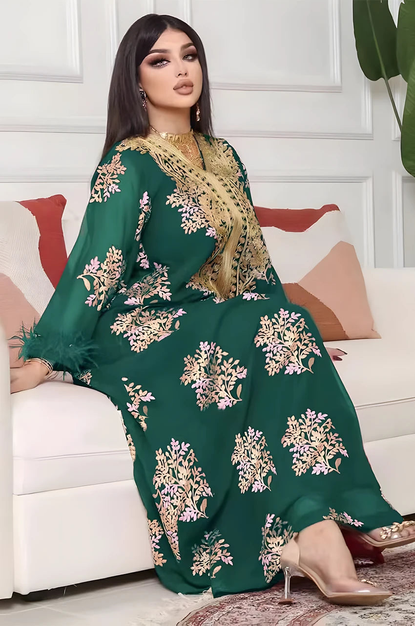 Lifestyle shot of model seated wearing the Mhaya emerald feather-sleeve kaftan.