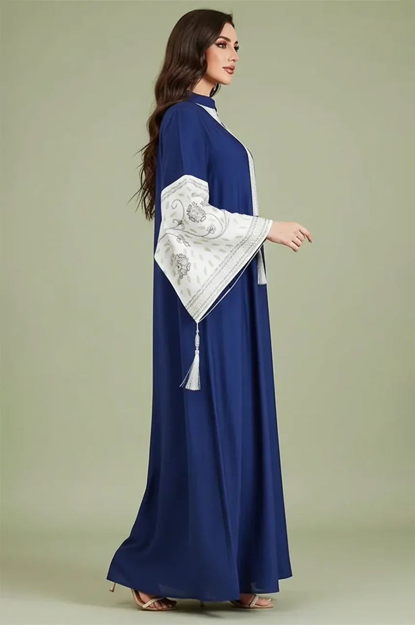 Side profile of the Nairi navy blue cotton kaftan maxi highlighting the dramatic sleeve flare and white embroidery
