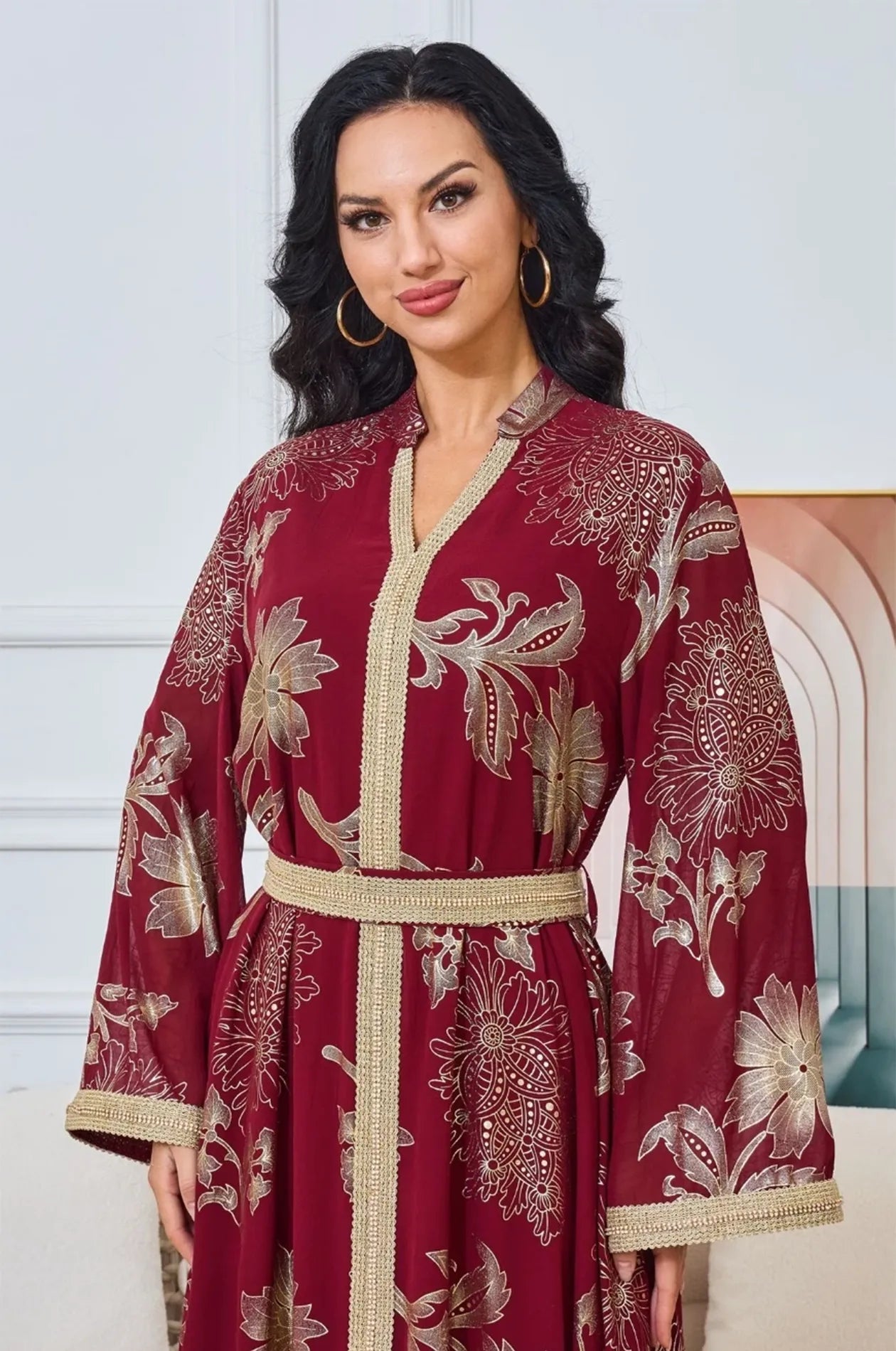 Close-up of the golden floral print and braided trim on the Ayrah maroon kaftan.