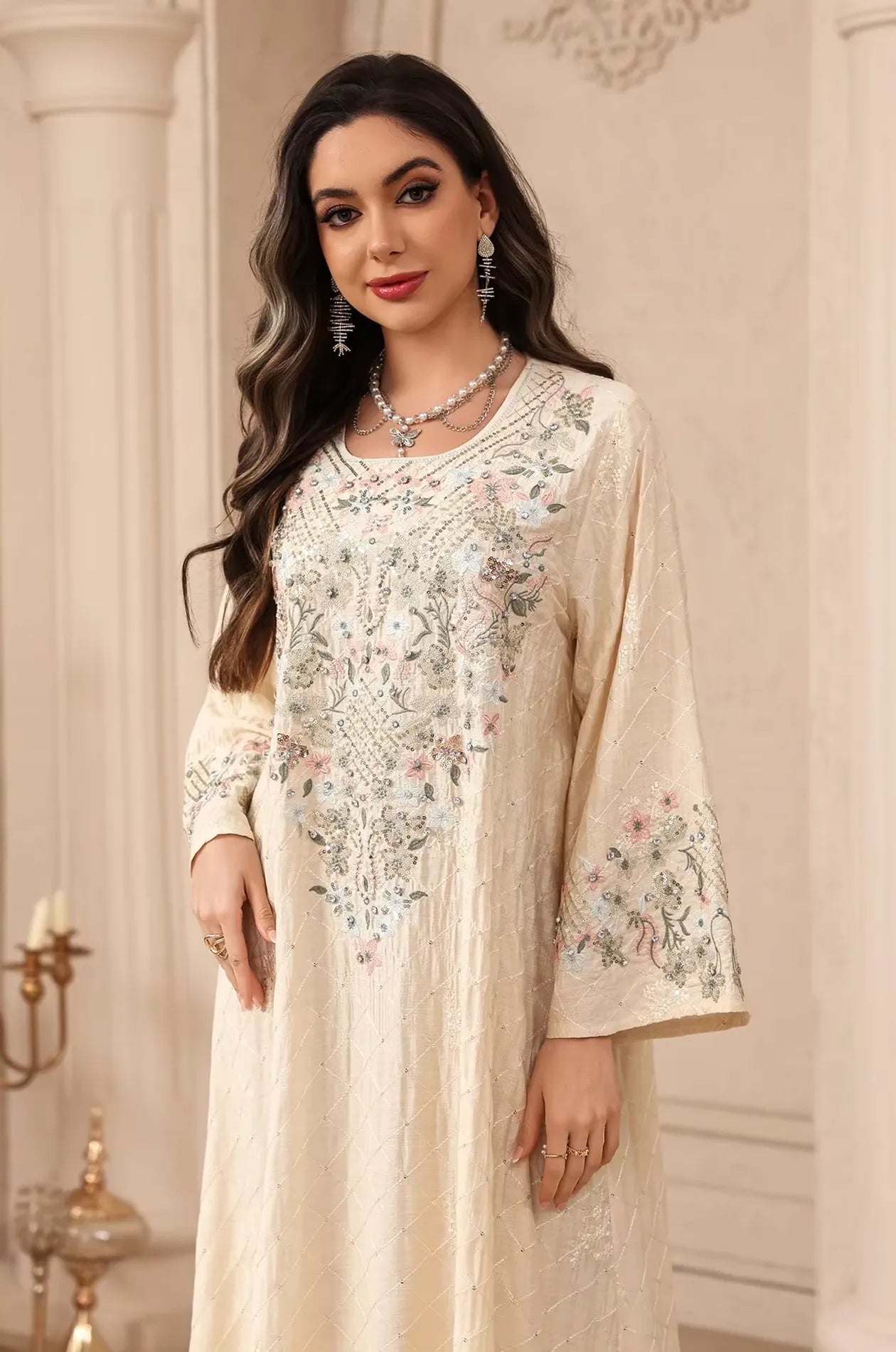 Portrait view of the beige Equis modest kaftan highlighting the intricate sequined floral bodice.