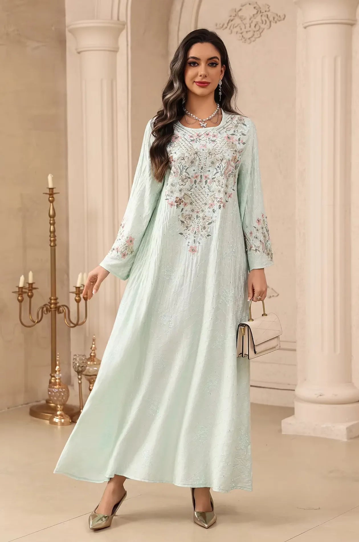 Fashion shot of the light green Equis modest kaftan with floral embellishments, styled for a luxury evening look.