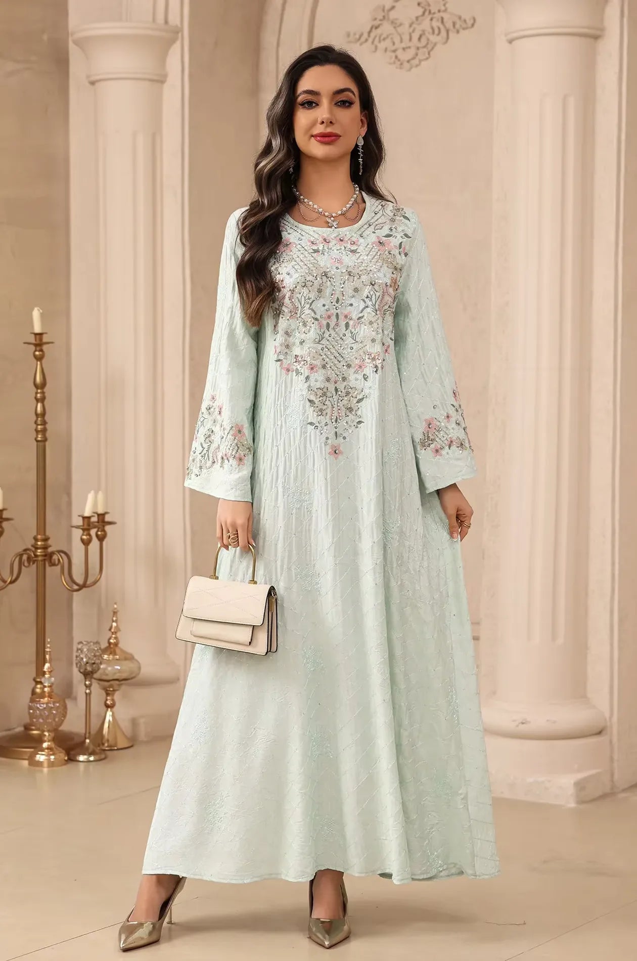 Model posing in the mint green Equis modest kaftan with long bell sleeves and a graceful floor-length drape.