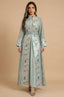 A full-length front view of the Gienah chic kaftan in light green by Naylara, featuring silver leaf embroidery and a belted waist.