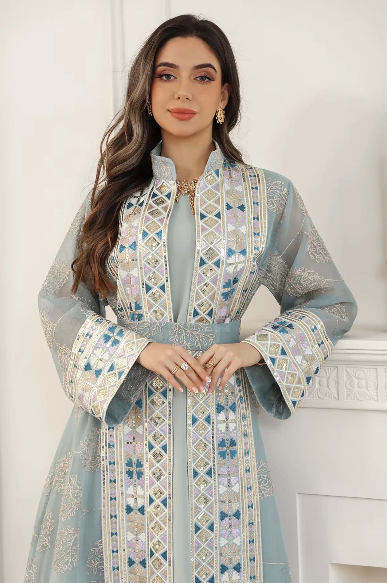 Mid-shot focus on the Gienah light green chic kaftan by Naylara, emphasizing the high-neck collar and embroidered waist belt.