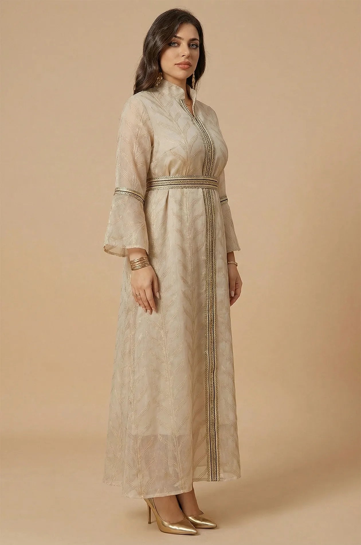 Side profile of a woman wearing the ivory beige Kitala Moroccan Kaftan, highlighting the sheer fabric and elegant gold thread work.