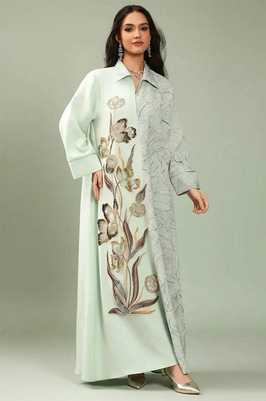 Studio front portrait of the Lamiya Sage Green a line kaftan dress with architectural pointed collar and silver-piped cuffs.