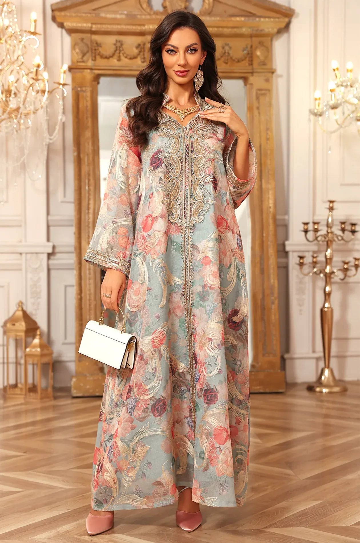 Full view of the Naylara Lyrae green luxury party kaftan with gold embroidery and a matching white clutch.