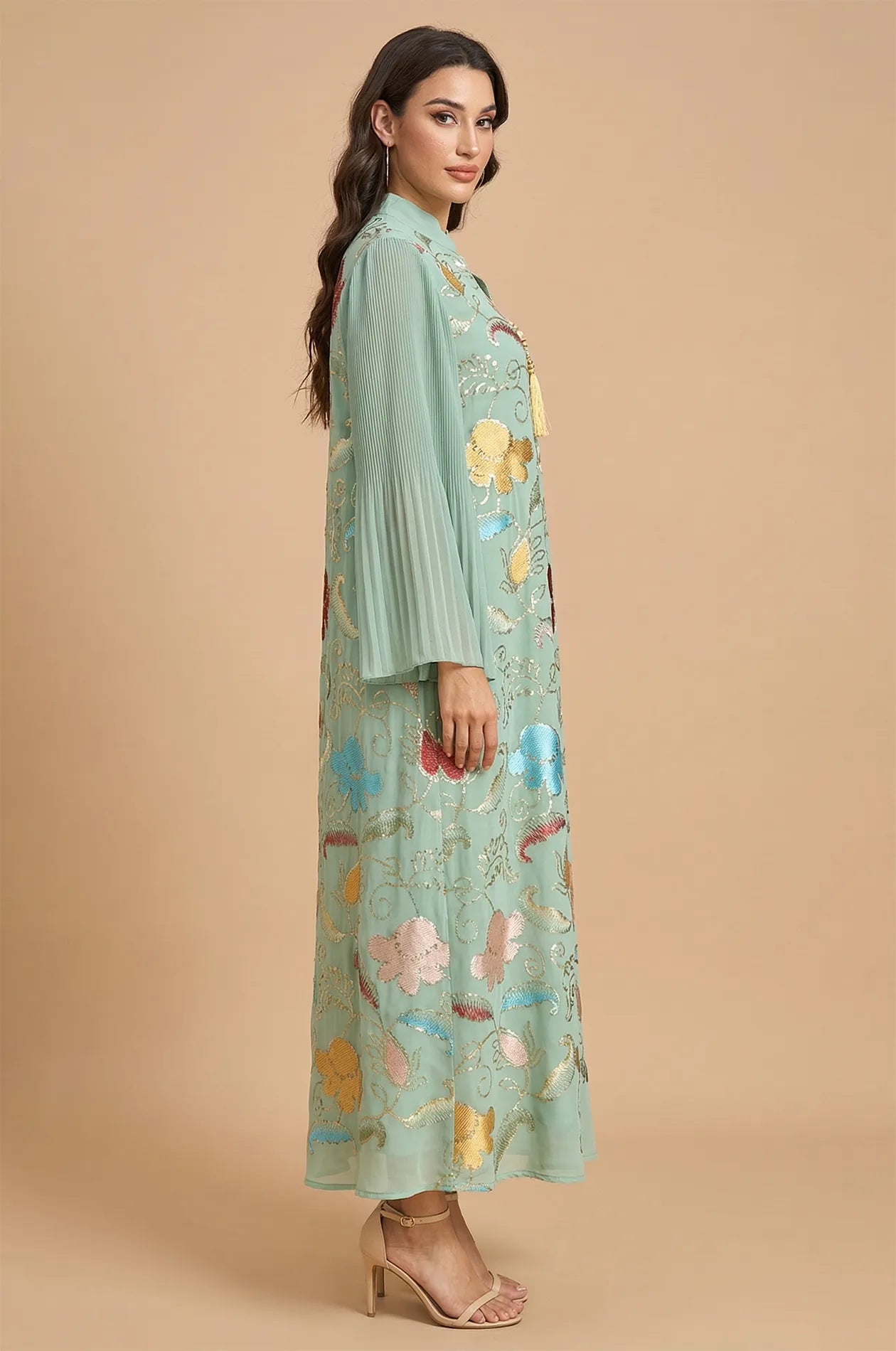 Side profile of the Marylin Green Tassel Kaftan at Naylara, highlighting the elegant pleated bell sleeves and floor-length design.