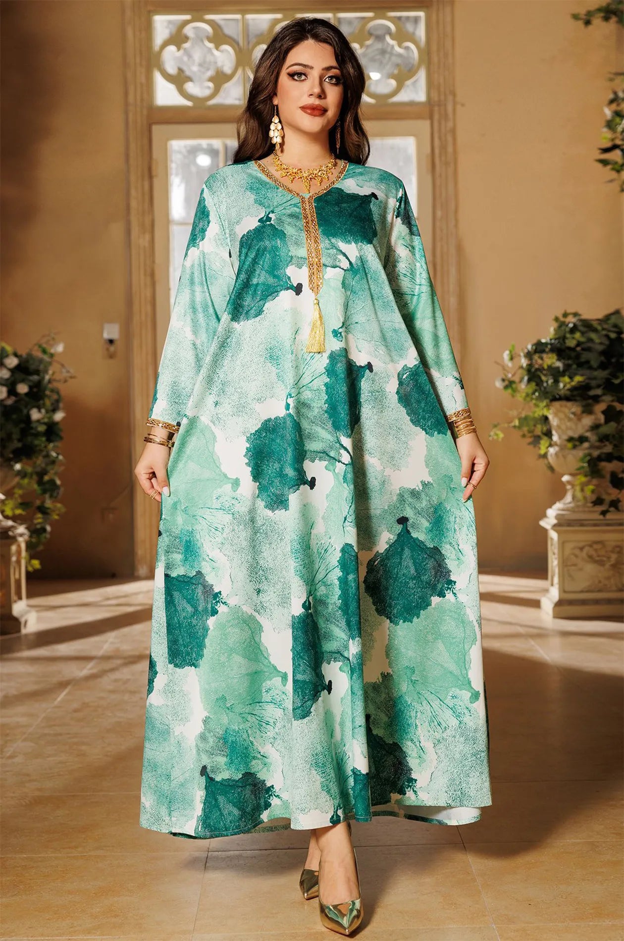 Full shot of the model showcasing the wide, flowing silhouette of the green Navae tropical print kaftan.