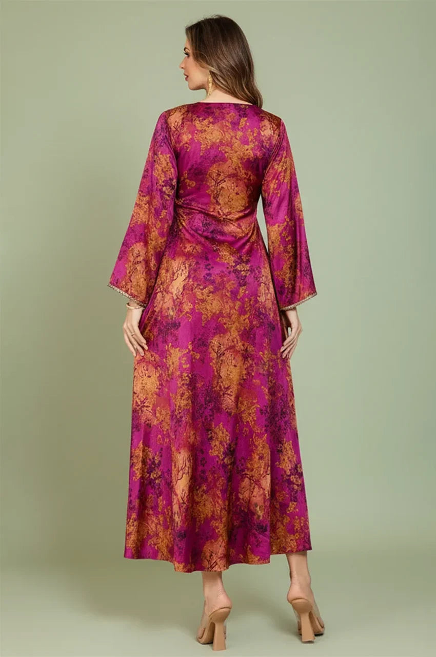 Rear view of the Noria fuchsia red fitted kaftan highlighting the flowy fabric and golden botanical print