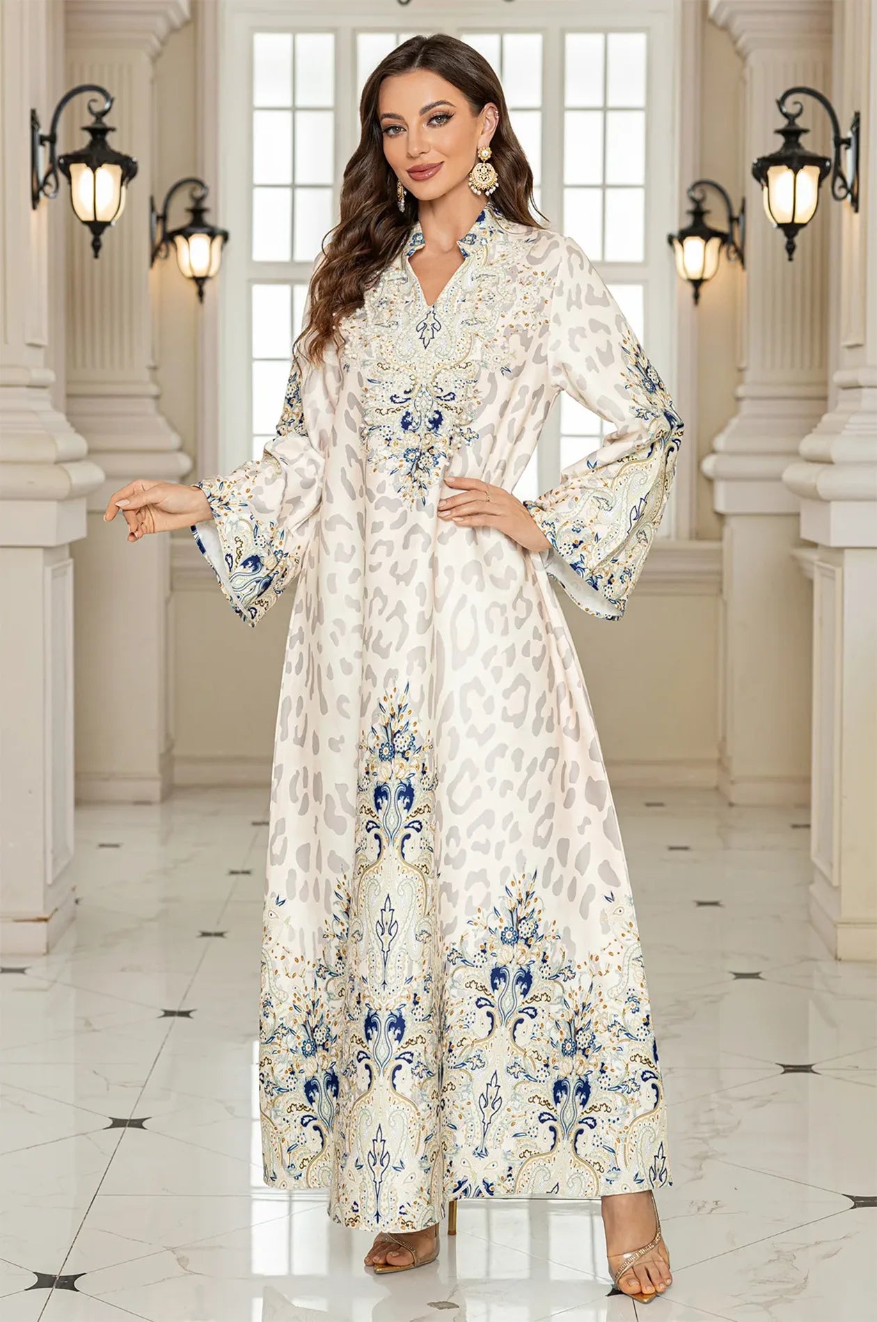 Model posing in the Nyx White Embellished Kaftan in a luxurious marble hall, showcasing a sophisticated and modern evening-wear look.