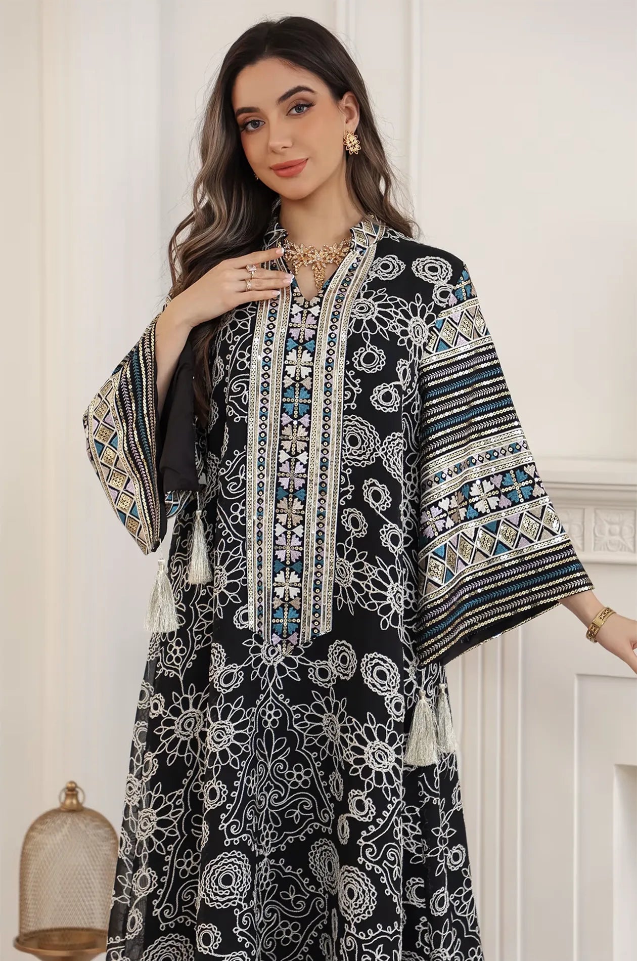 Close-up front view of the Naylara Orla black bell sleeve kaftan featuring intricate white floral embroidery and a sequined V-neckline.