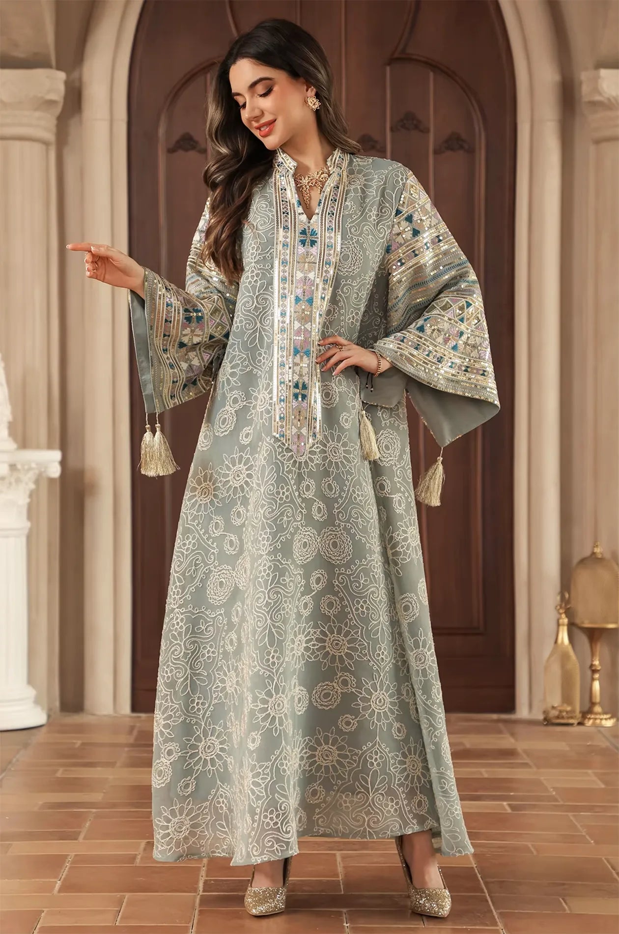 Model posing in the Orla light green bell sleeve kaftan showcasing the dynamic movement of the tassel accents.