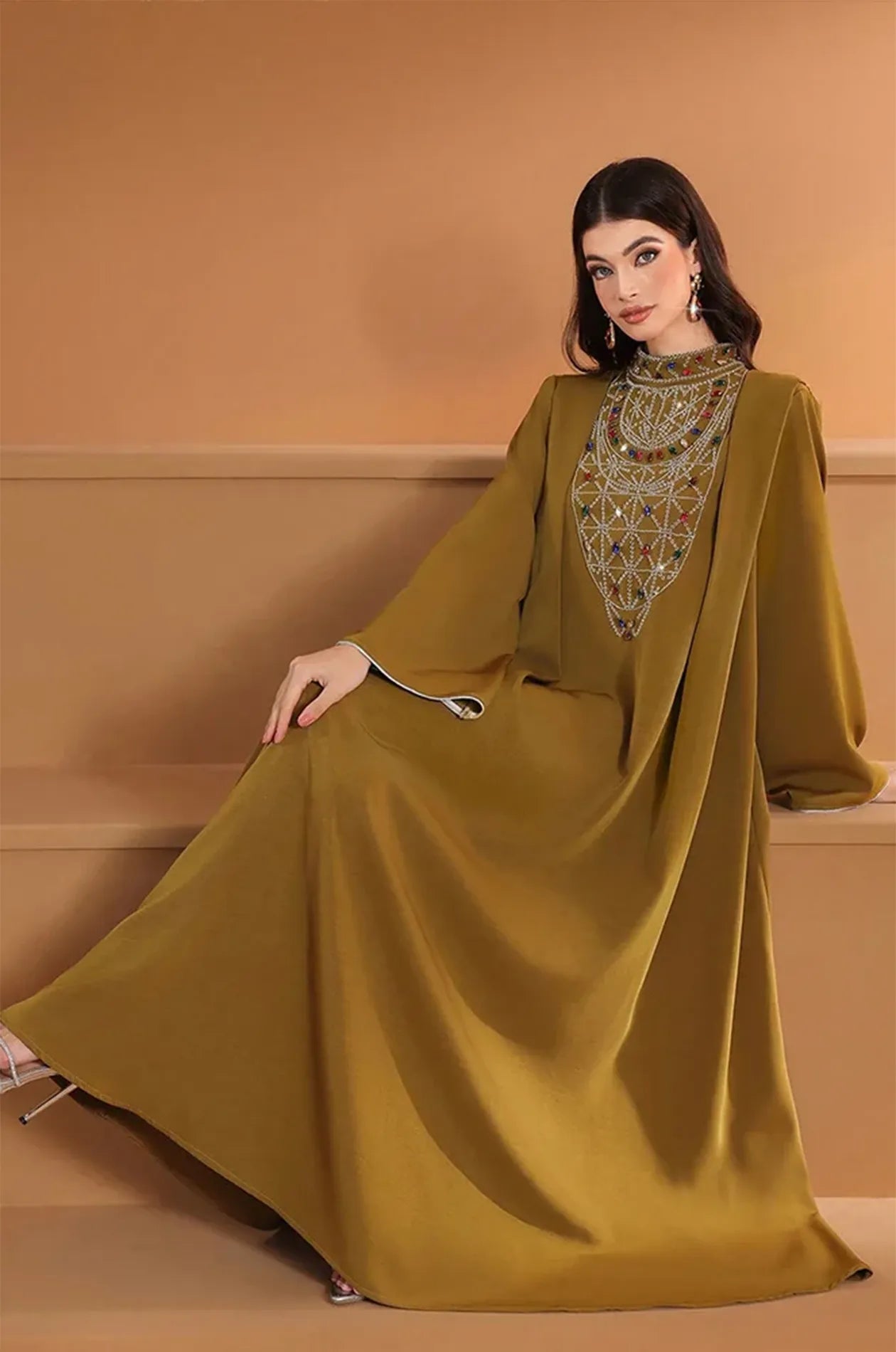 Seated view of the Rami kaftan illustrating the generous fabric and elegant drape.