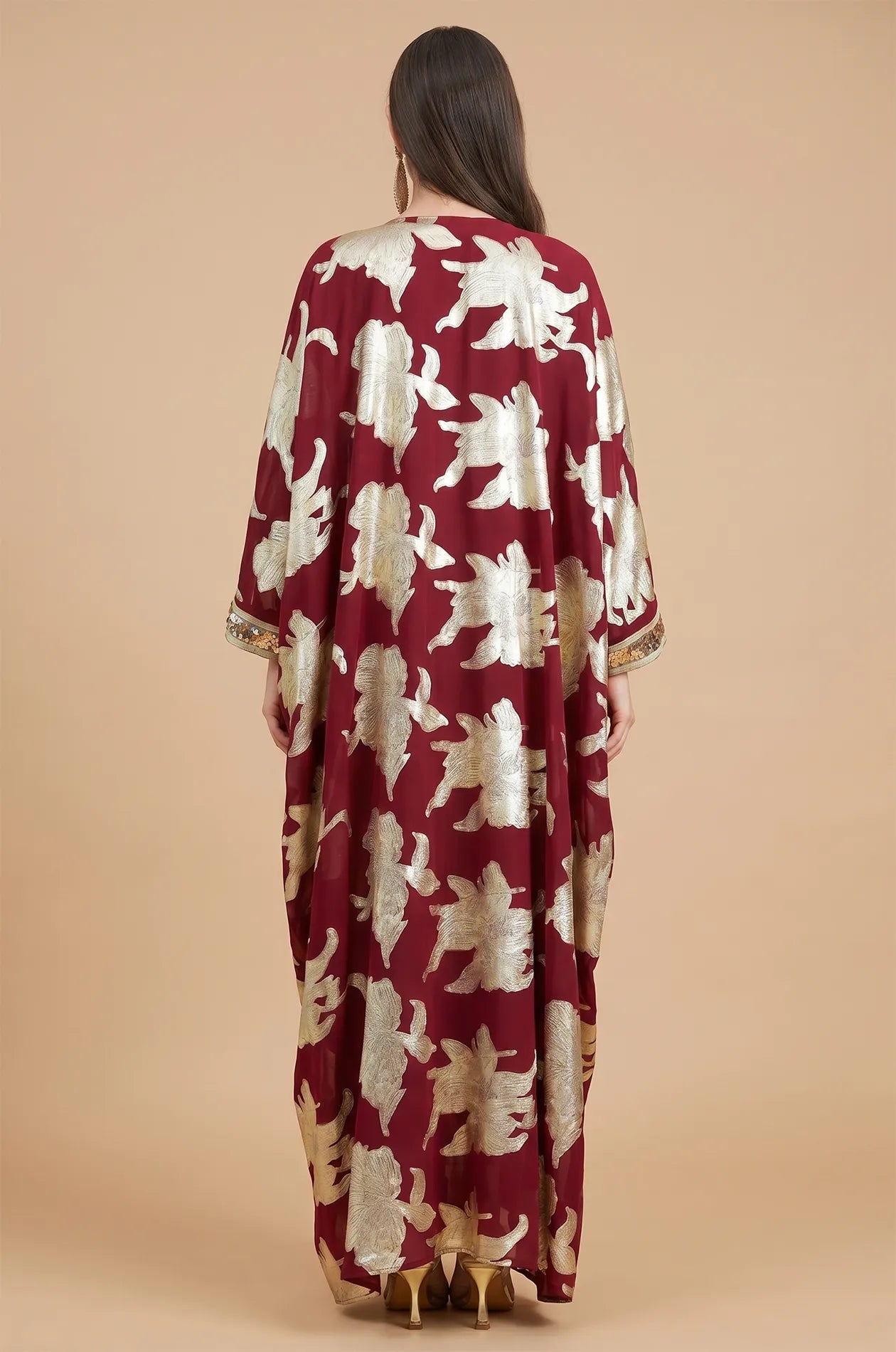 Full back view of the burgundy red Puppis kaftan luxe showcasing the continuous gold botanical pattern and elegant floor-length drape.