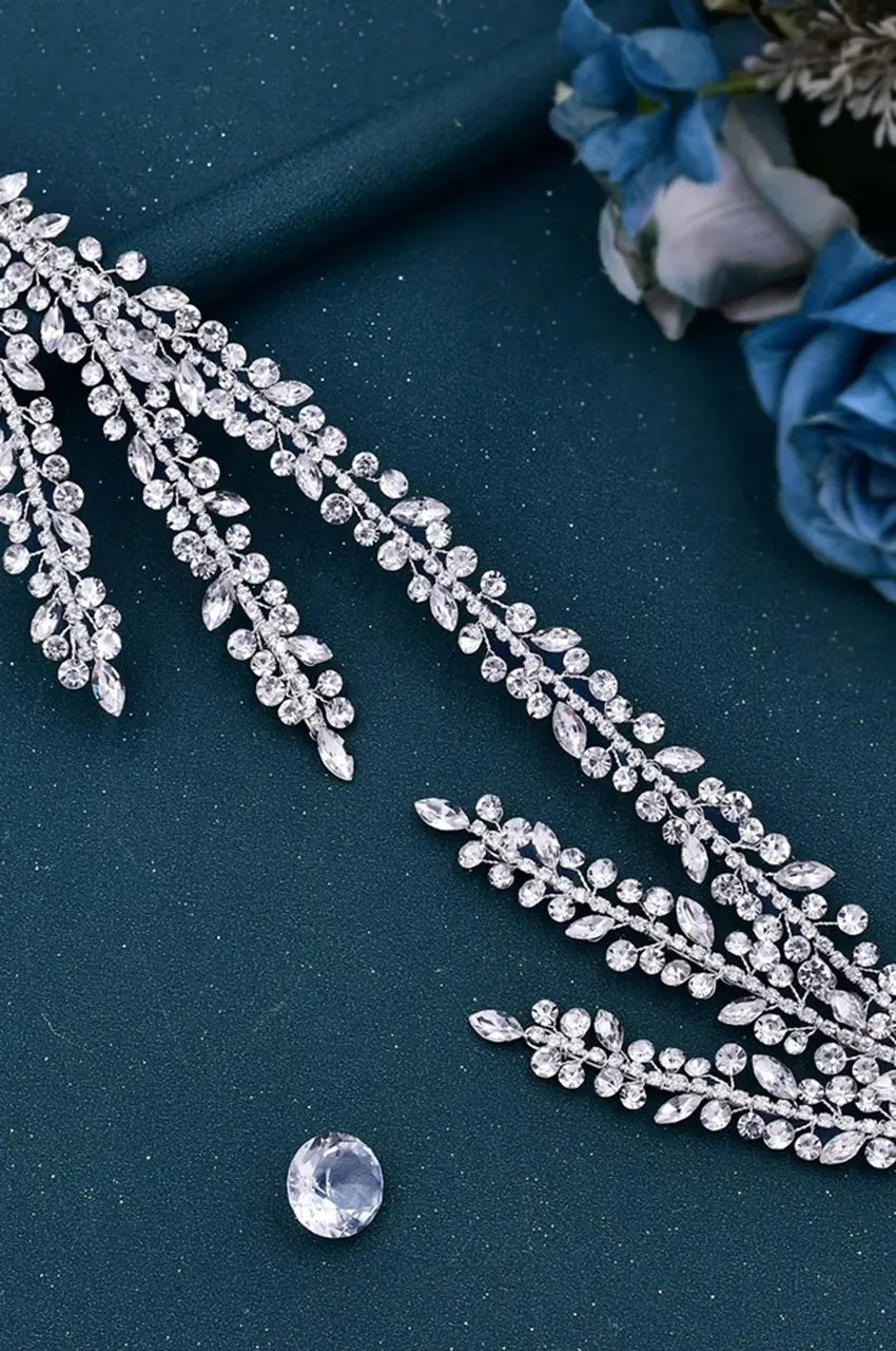 Lay-flat view of the flexible Silver Crystal Headpiece on a dark background, showing the scattered rhinestone elements and the overall length/design with multiple sparkling rows.