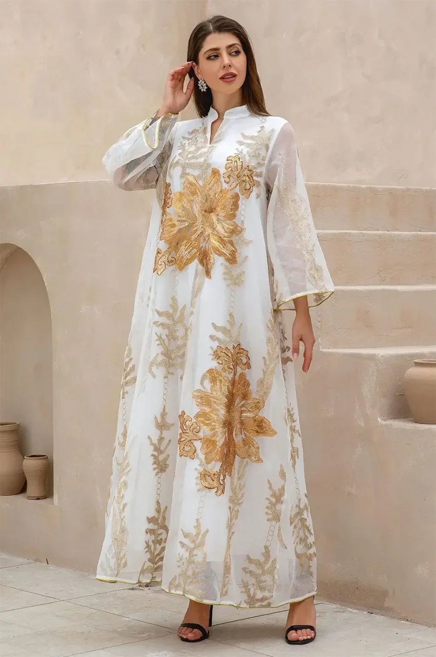 Elegant pose featuring the Naylara white flower kaftan with oversized gold sequins and sheer fabric layers.